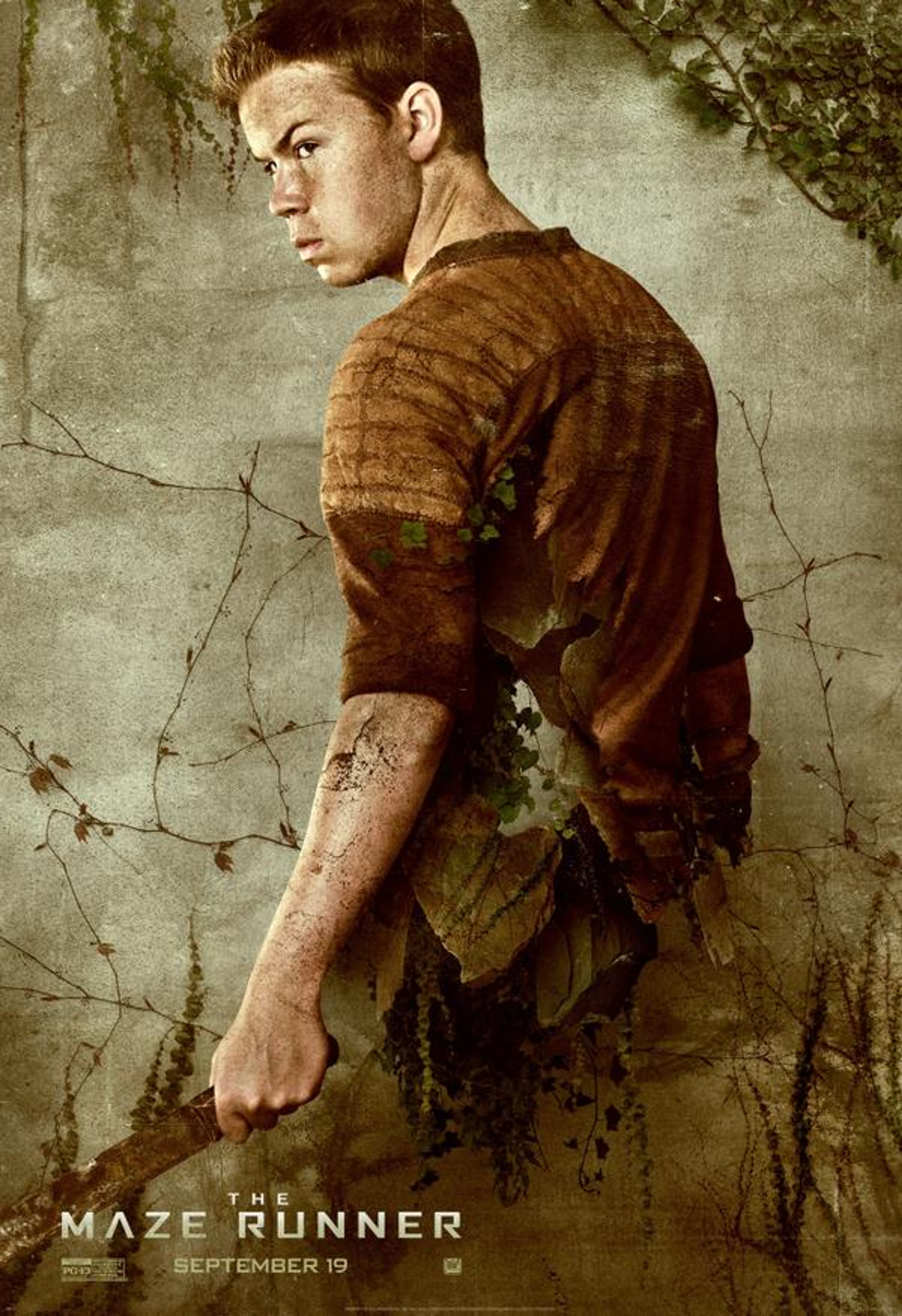 A young man with a serious expression, wearing a brown jacket against a gritty background.