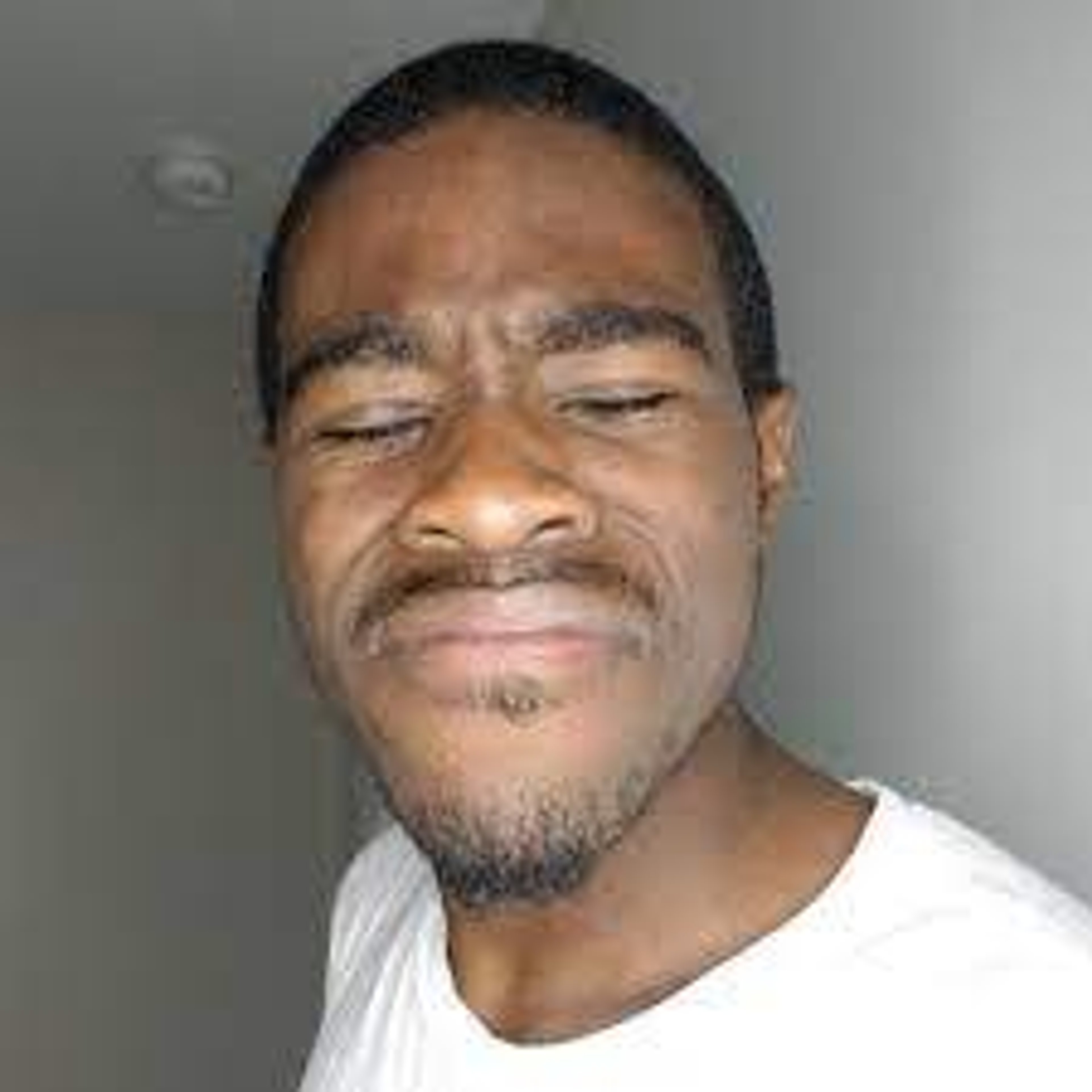 A middle-aged Black man with a beard and serious expression