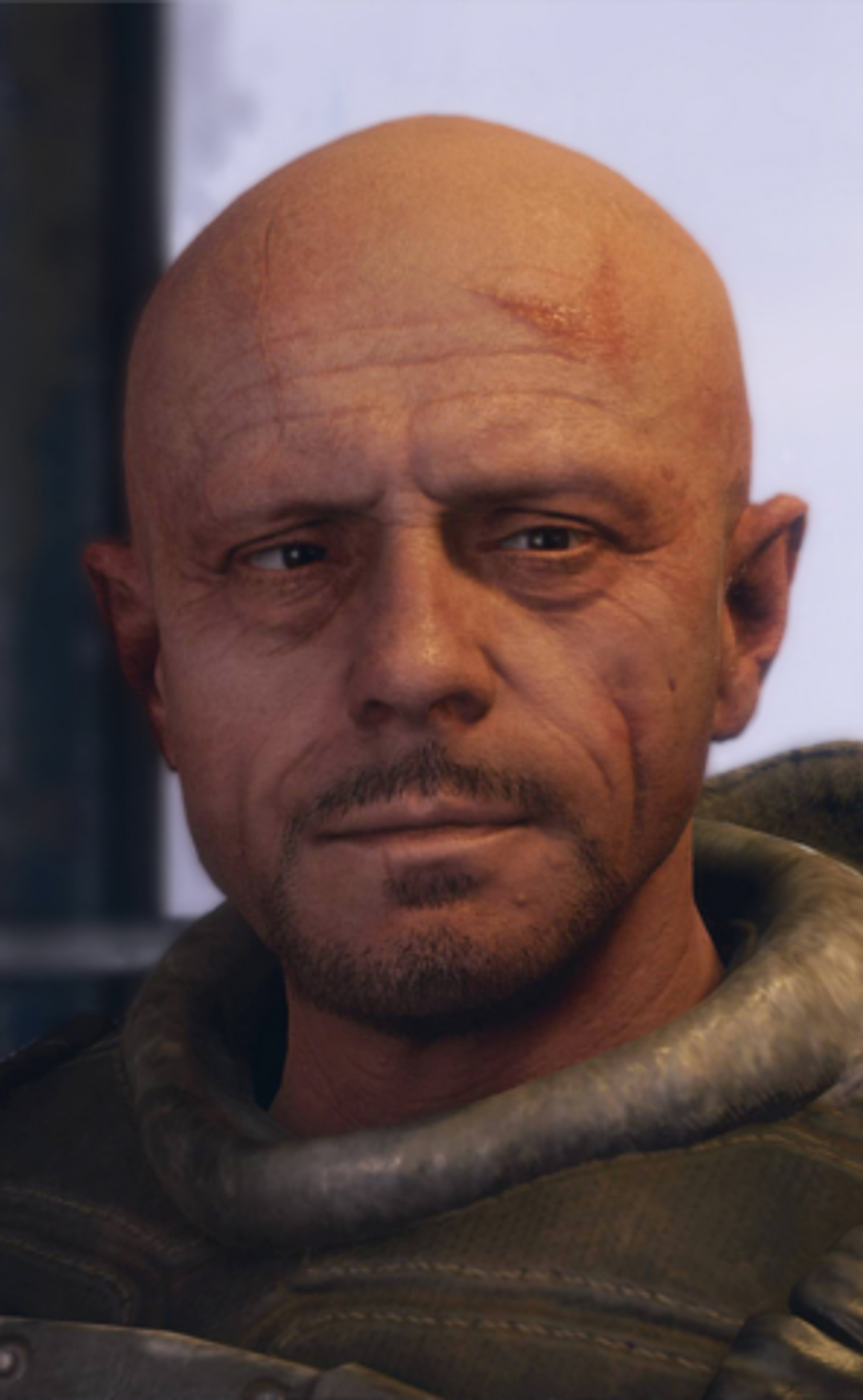 A bald, middle-aged man with a beard wearing a military-style jacket