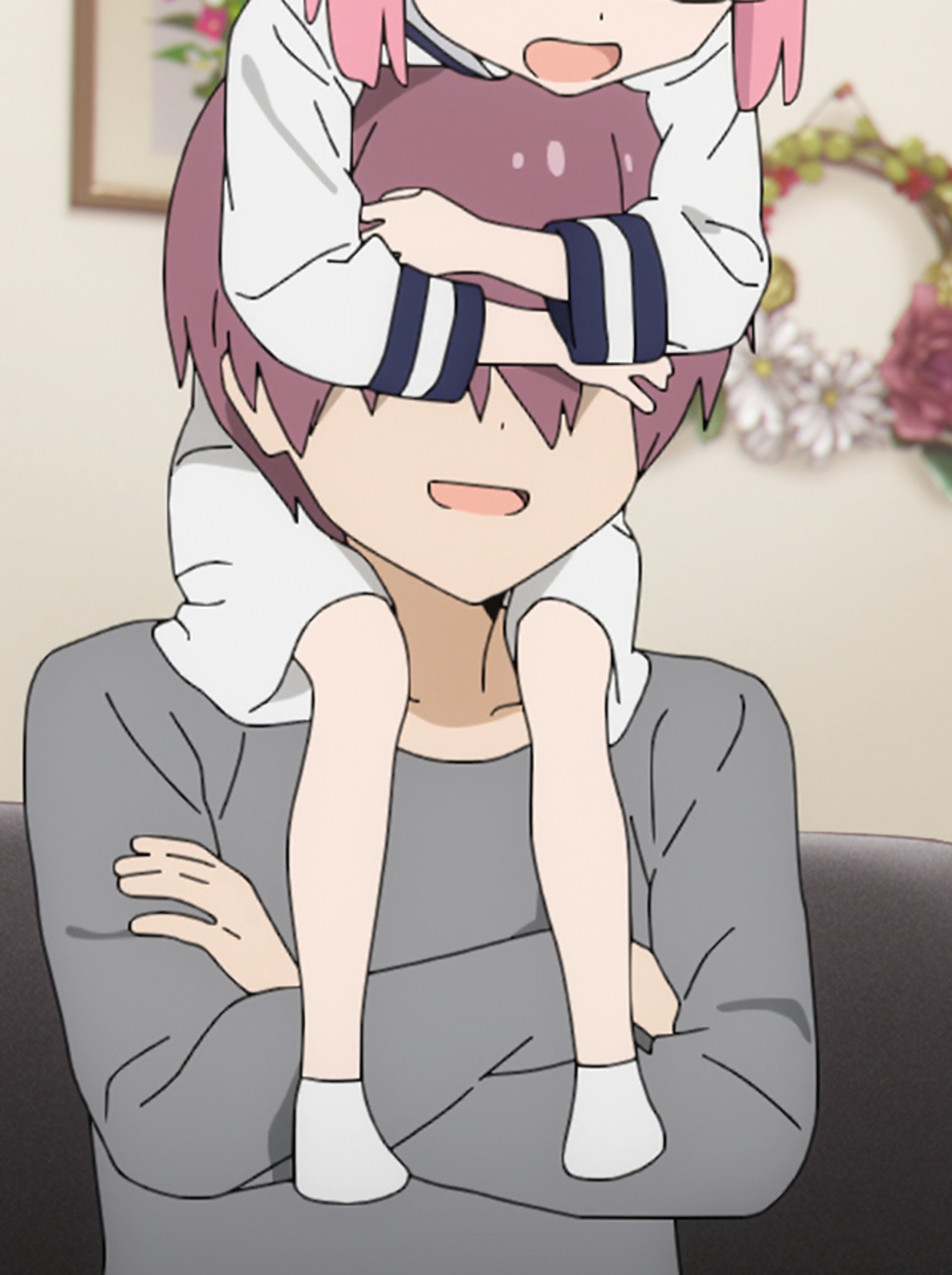 A middle-aged man with short, dark hair and glasses, wearing a gray sweater or jacket and having a thoughtful expression on his face.