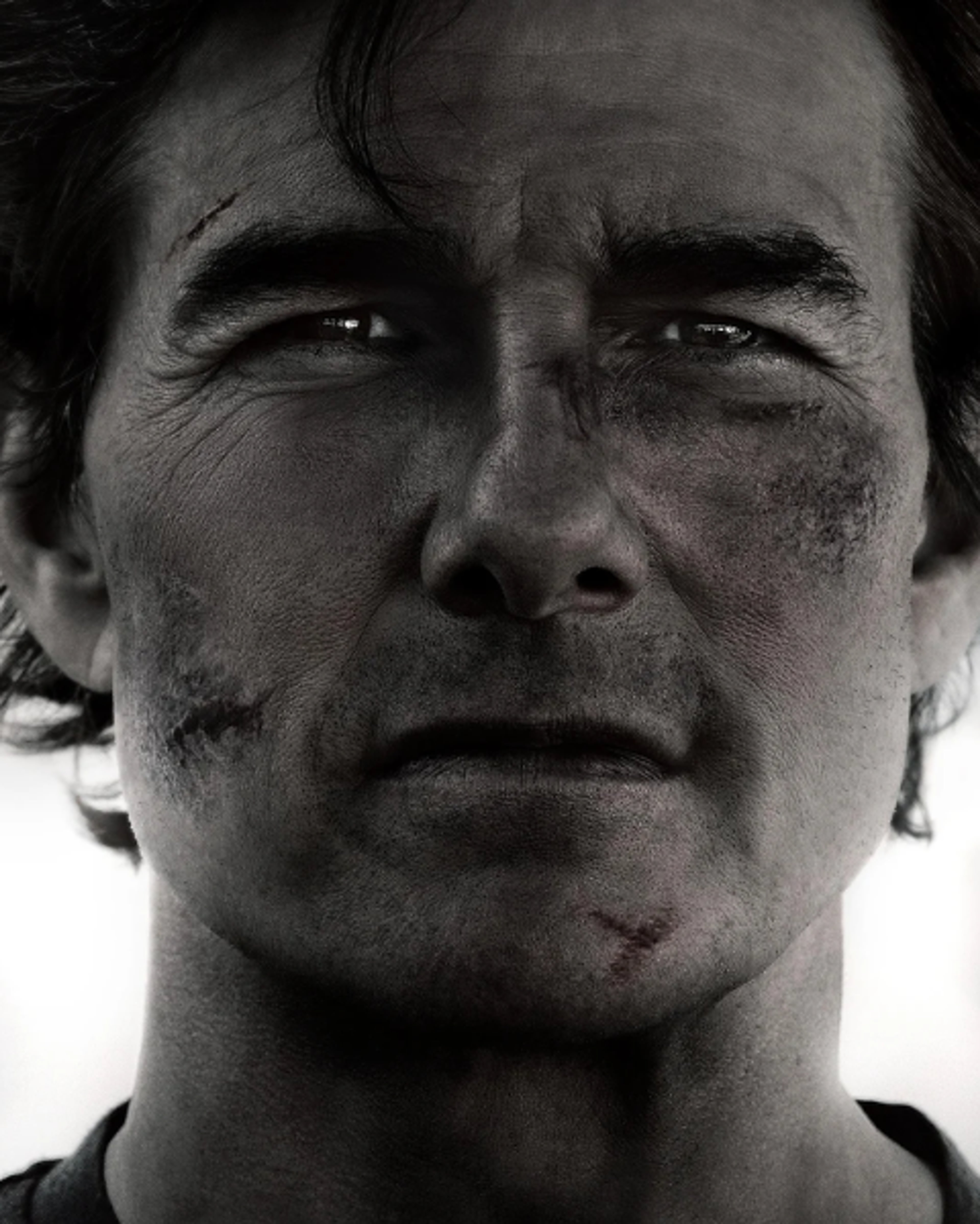 A close-up portrait of a middle-aged man with a rugged, intense expression