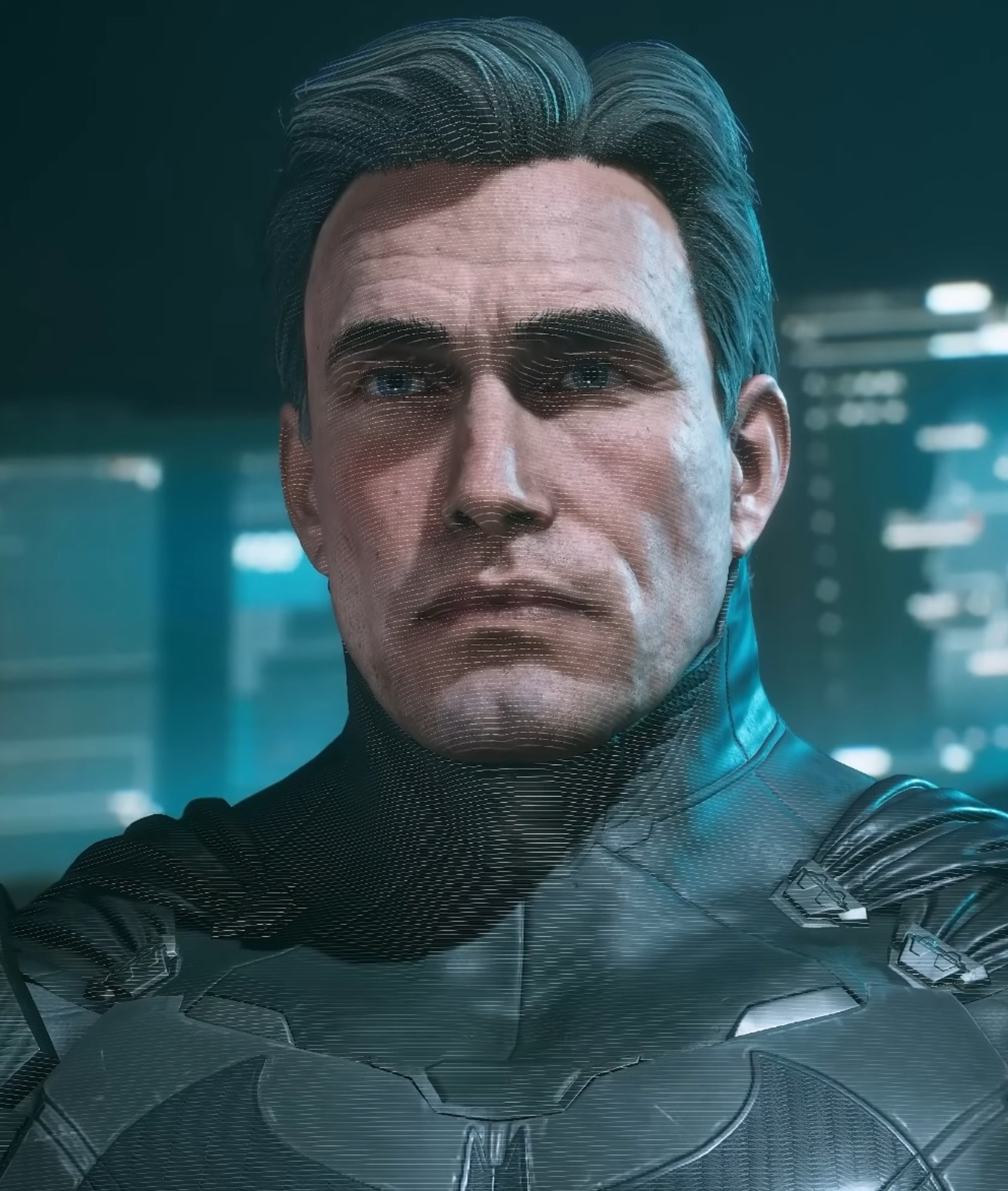 A man in a black tactical suit with a serious expression