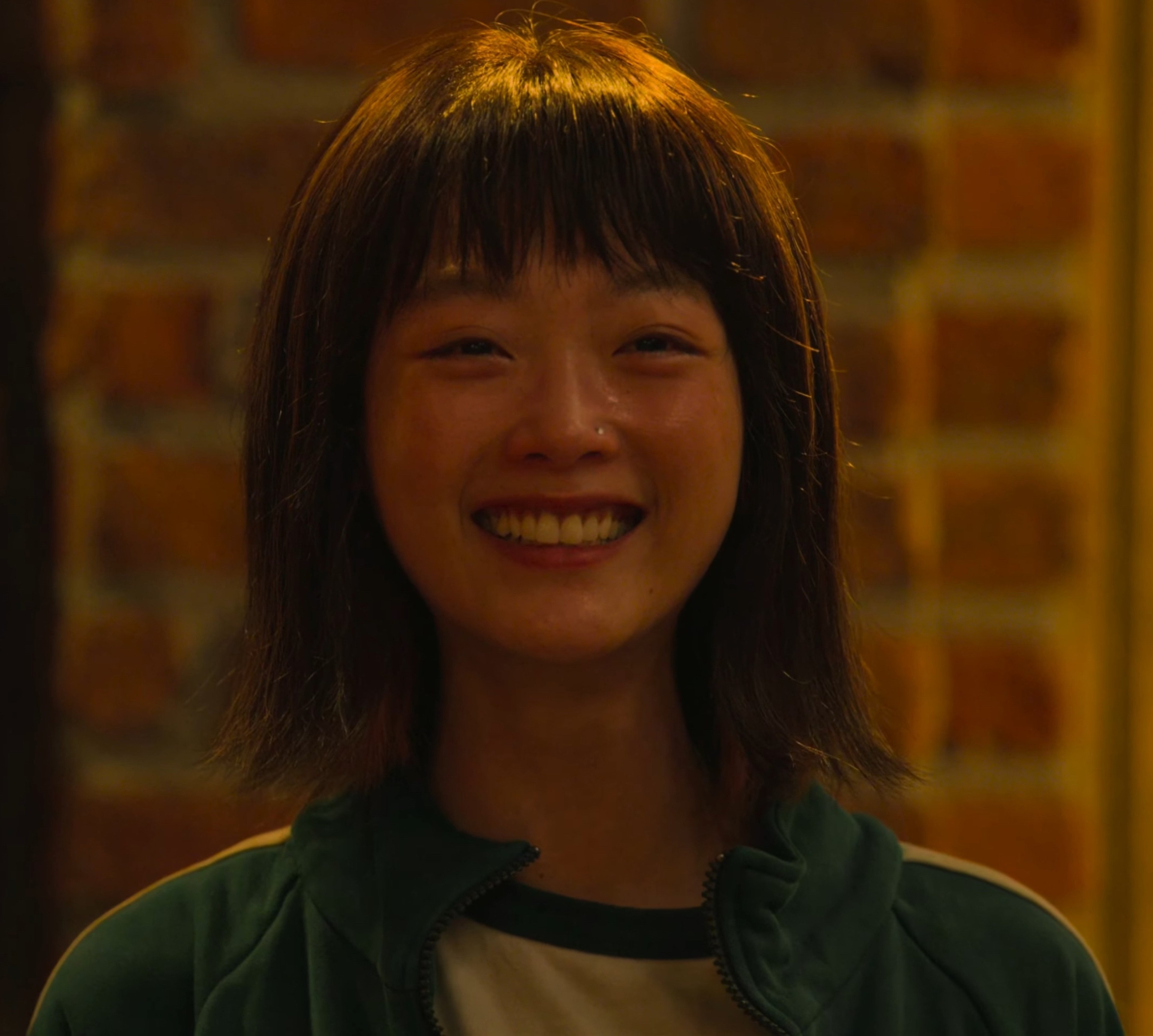 A young Asian woman with short black hair smiling warmly