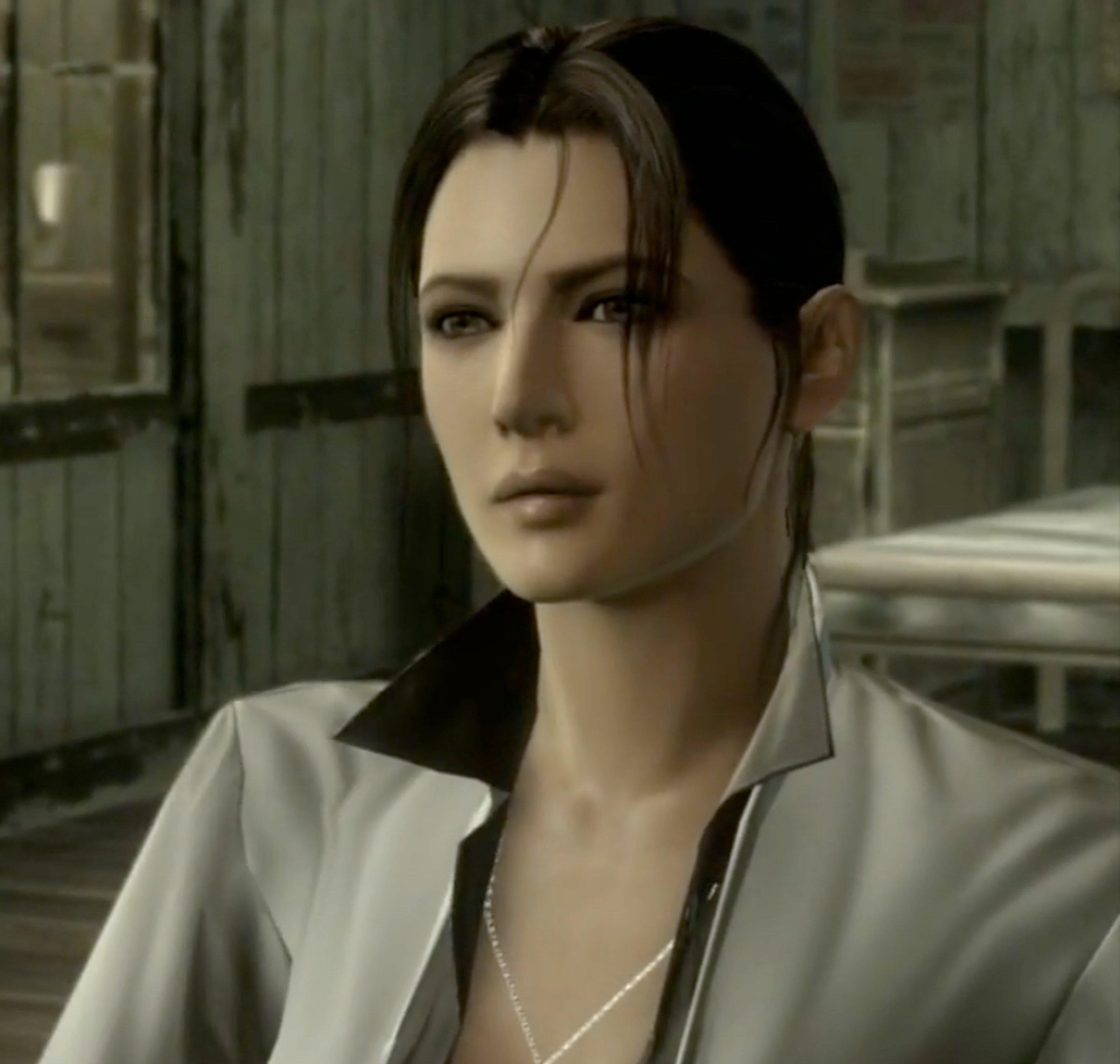 A woman with dark hair wearing a white shirt, looking serious and intense.