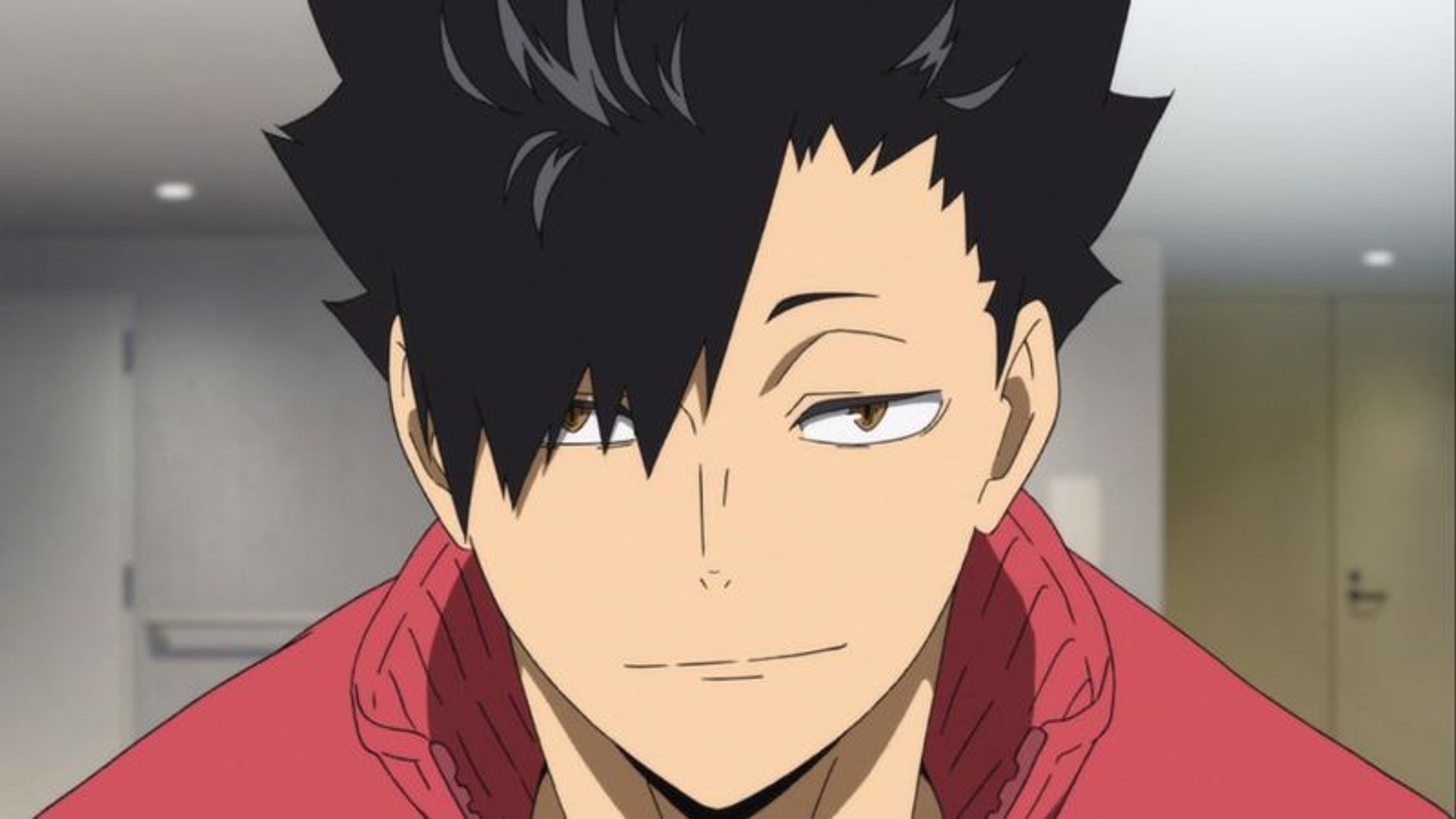 A young man with messy black hair and a red jacket, with a sly expression on his face.