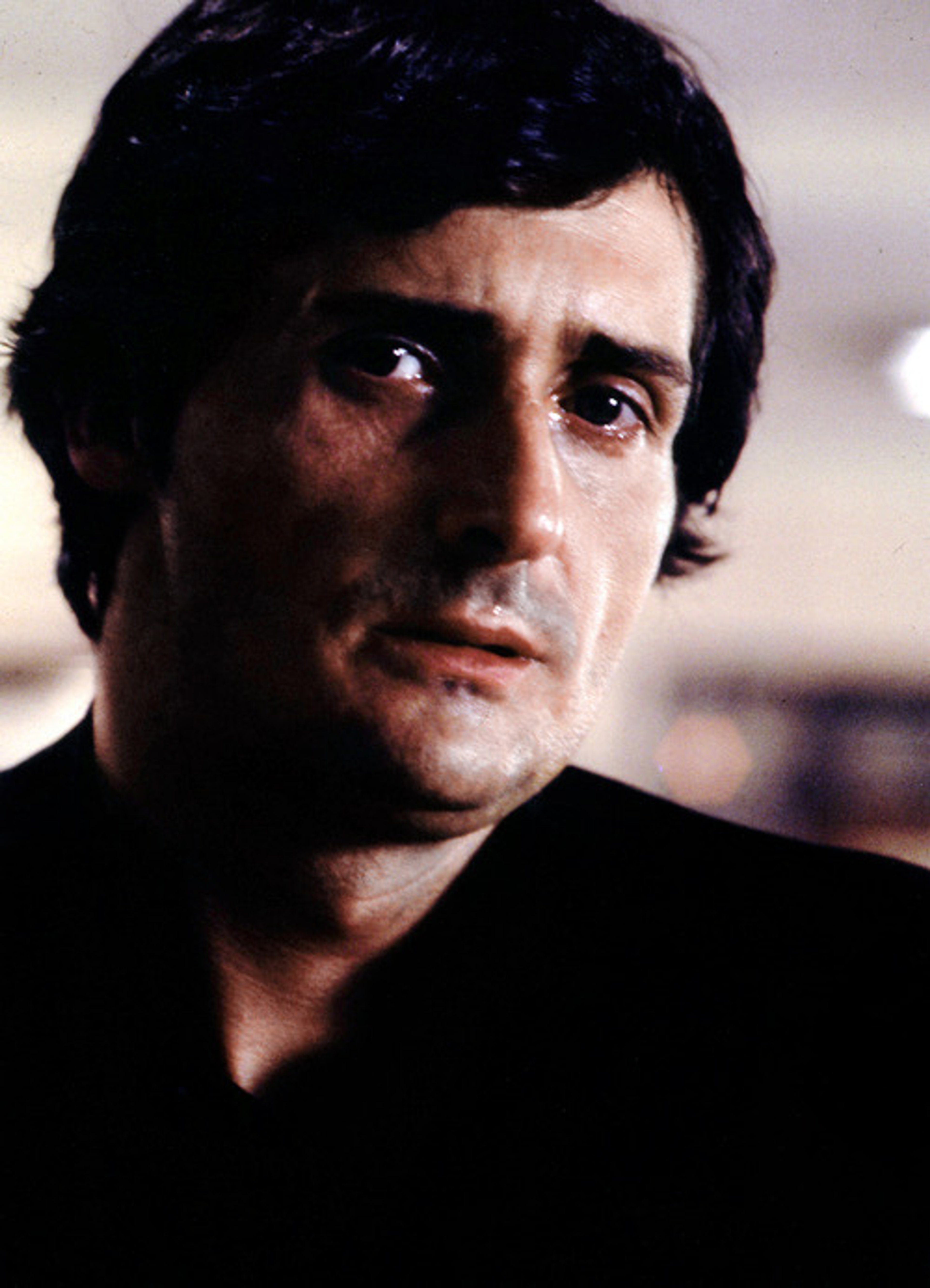 A middle-aged man with a serious expression, wearing a dark jacket