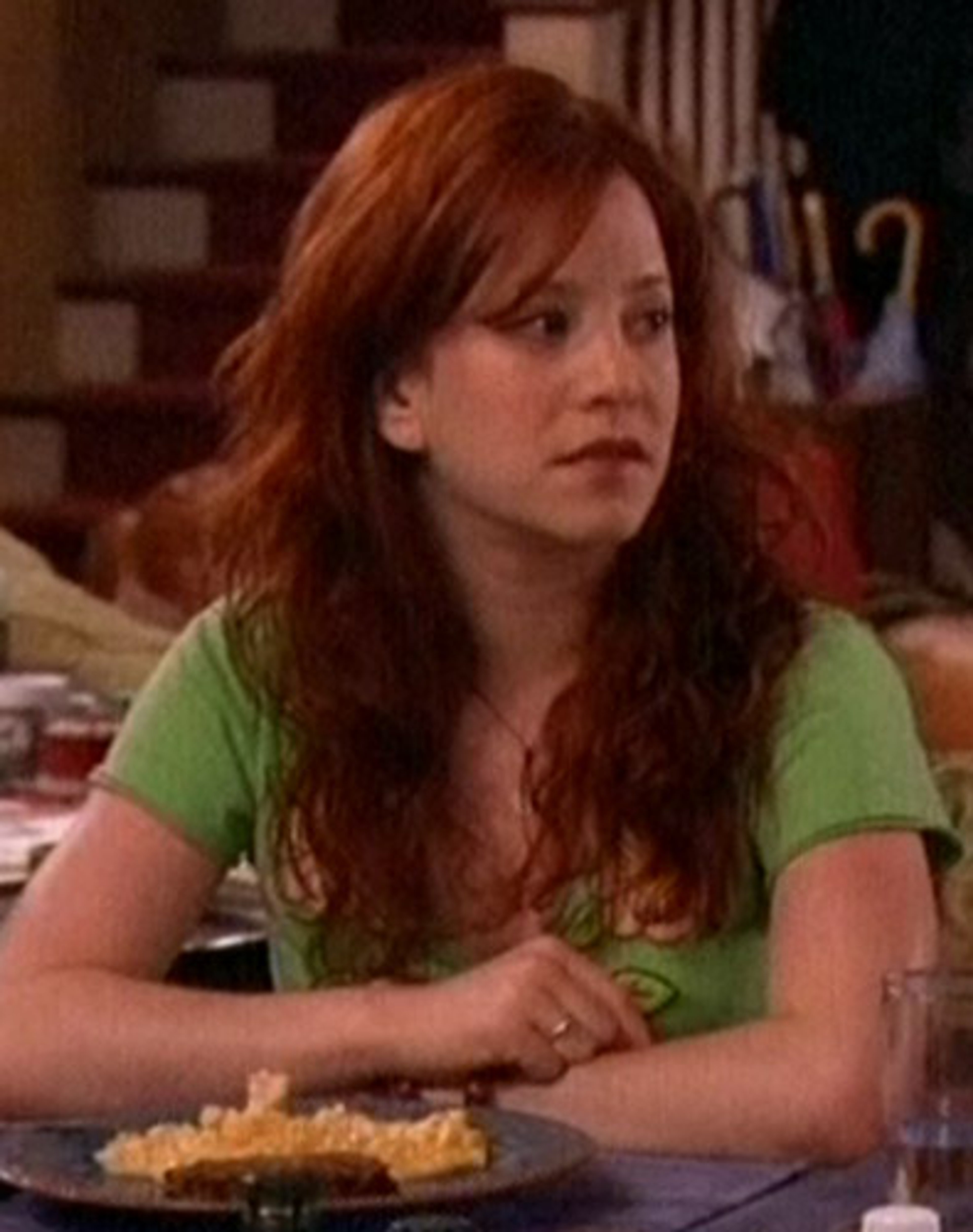 A young woman with red hair sitting at a table