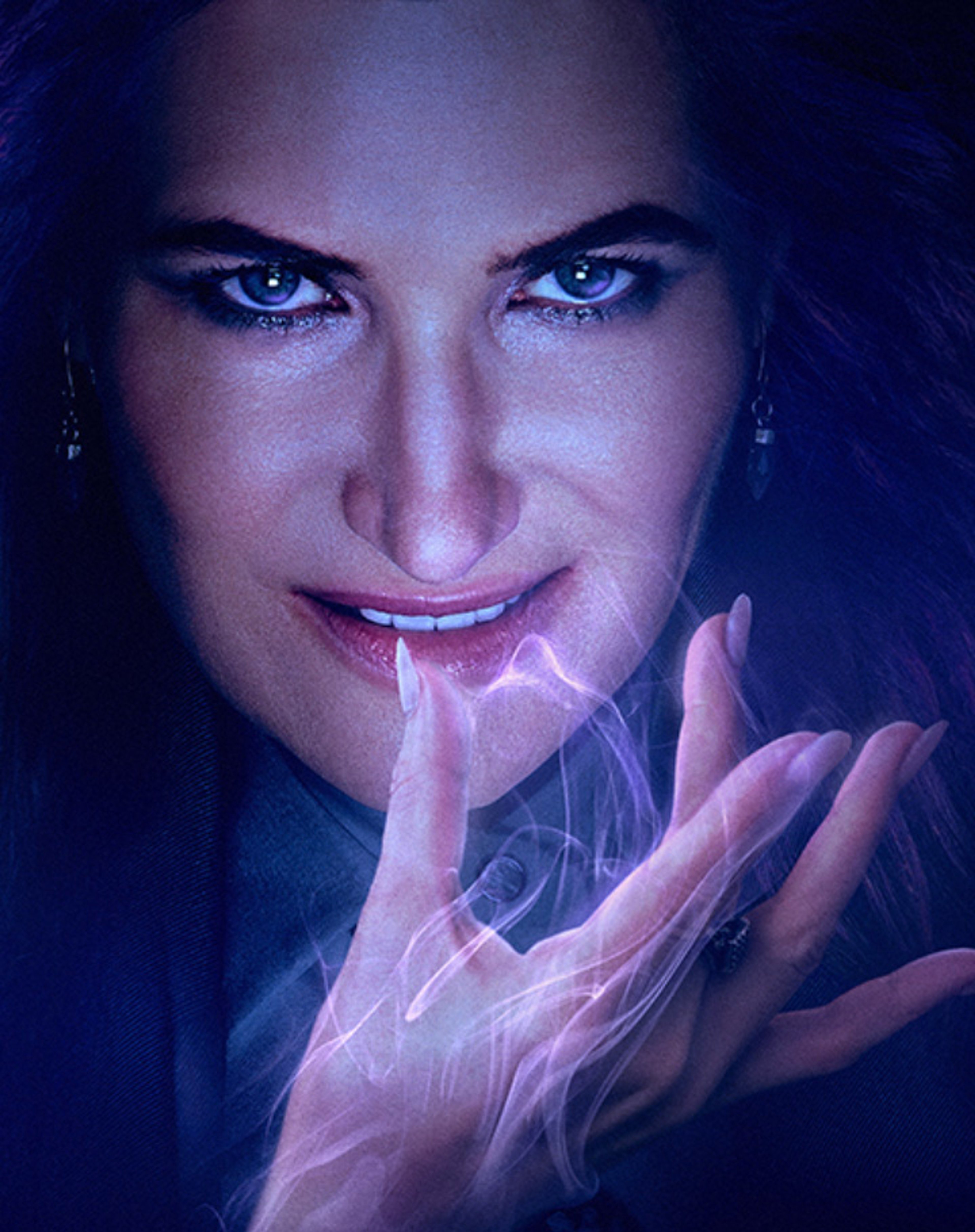 A close-up portrait of a woman with dark hair and intense blue eyes, making a shushing gesture.