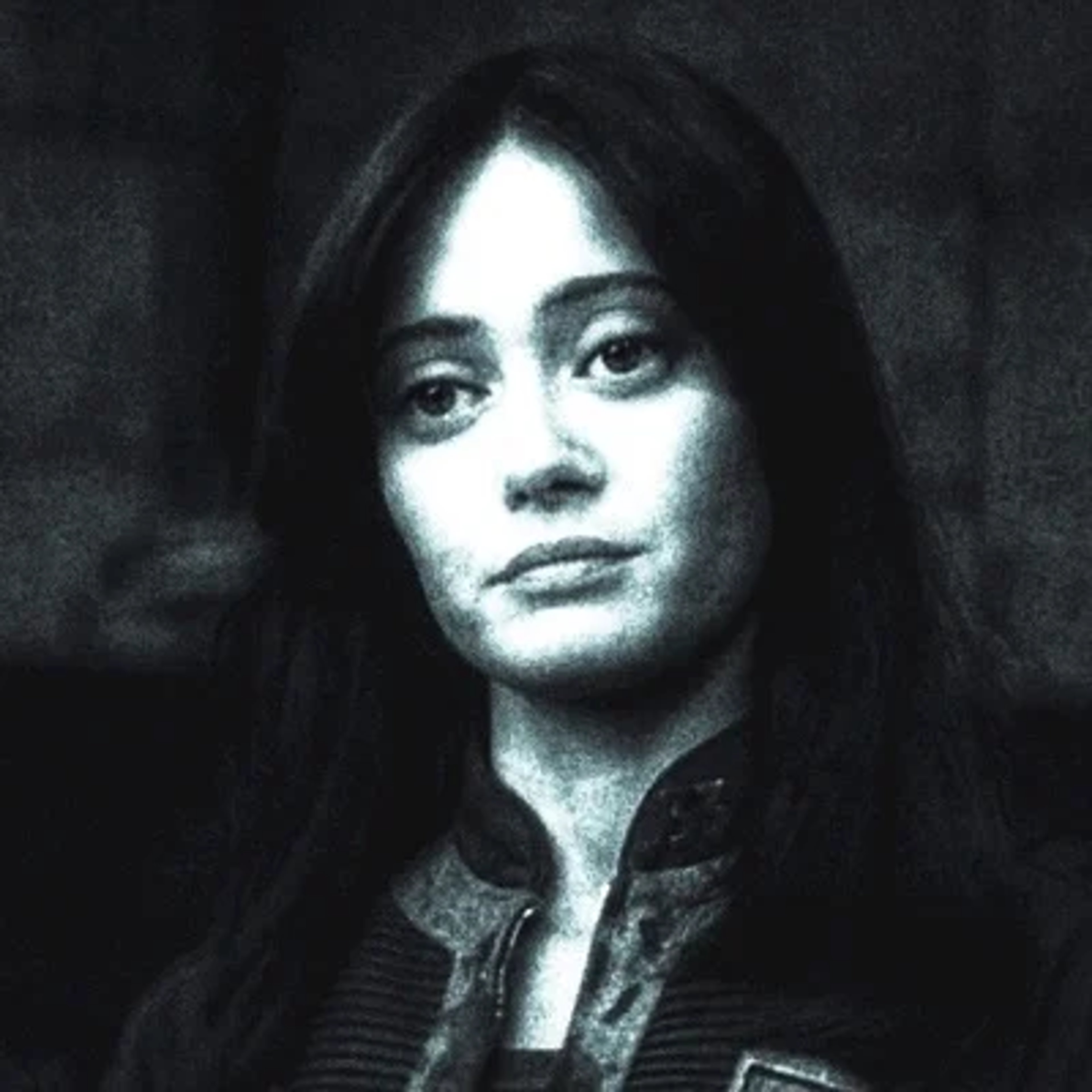 A black and white portrait of a young woman with dark hair and a serious expression.