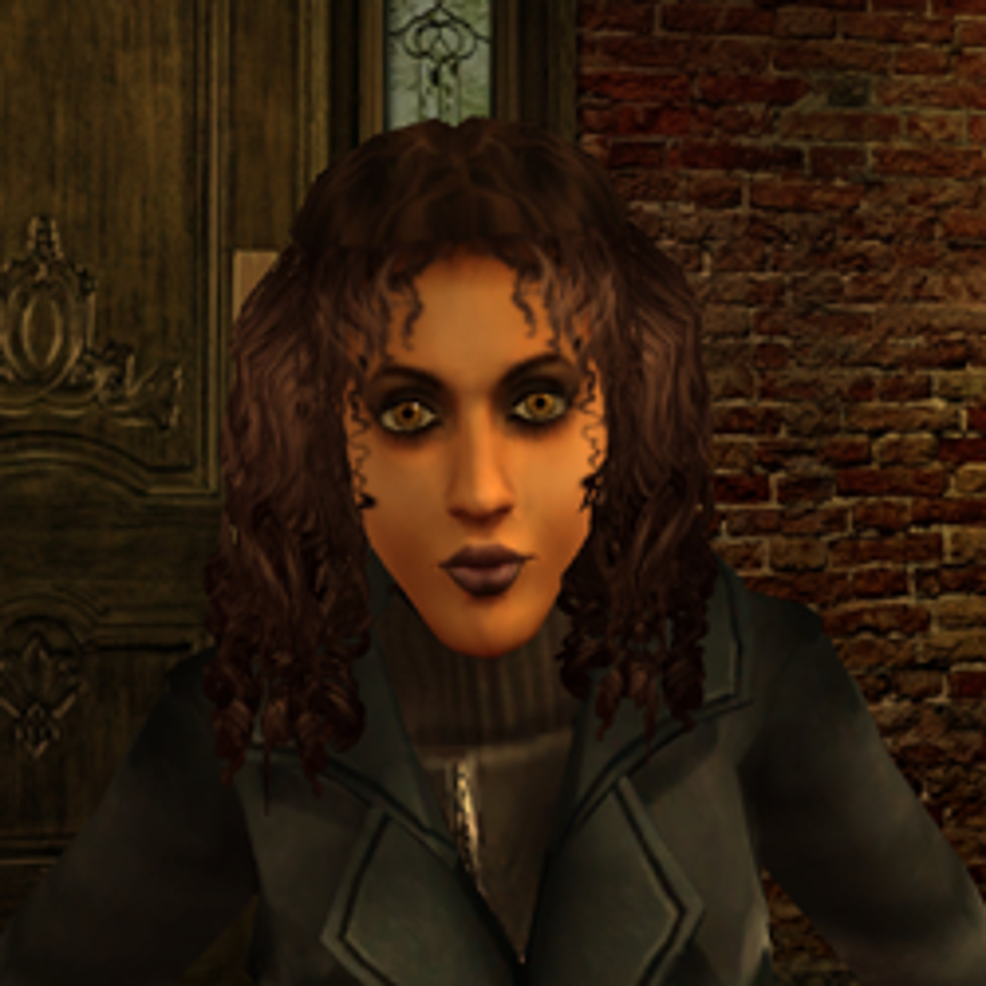 A woman with dark, curly hair and heavy eye makeup wearing a black jacket against a brick wall background.