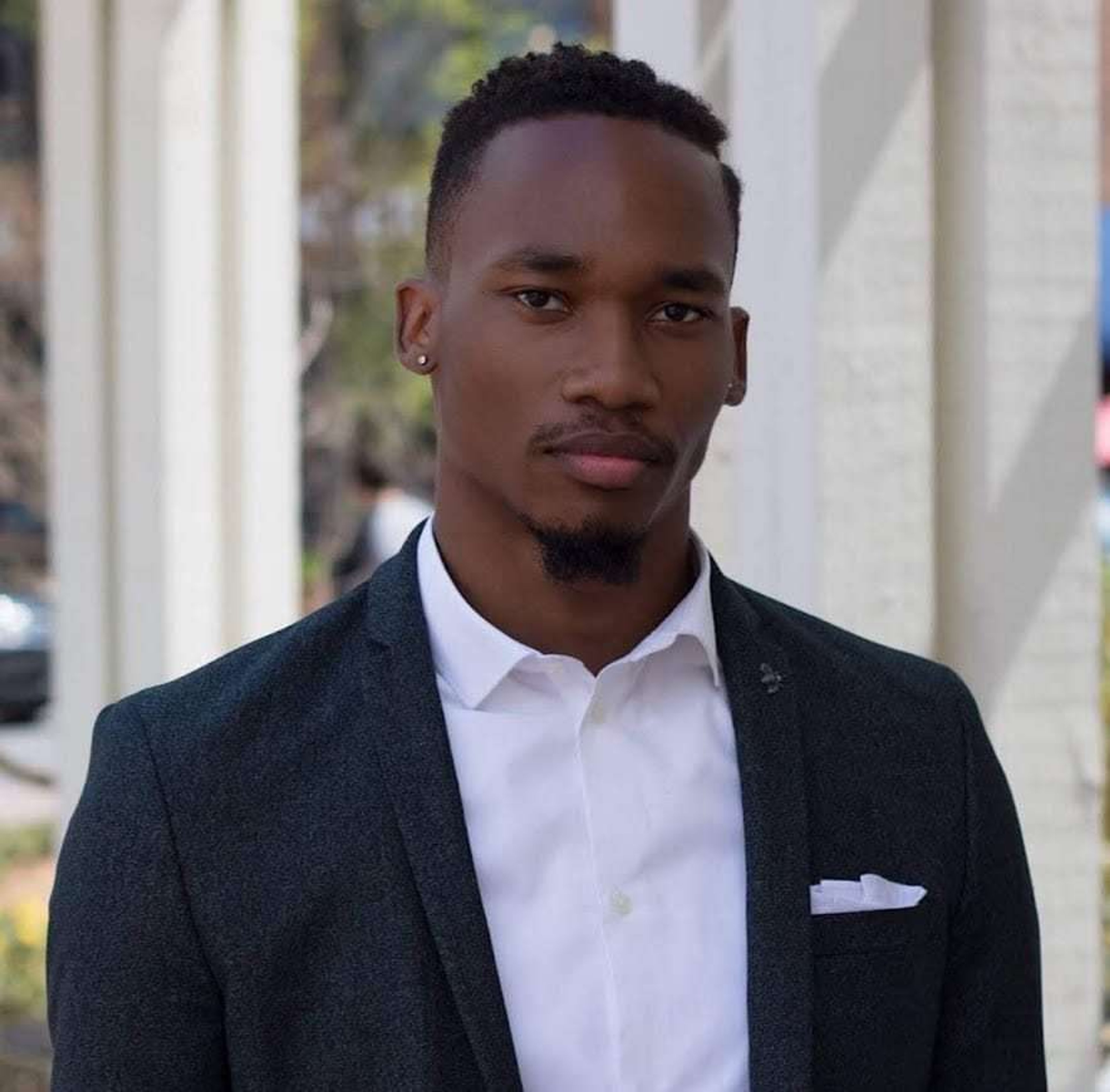 A Black man in a suit and tie with a serious expression