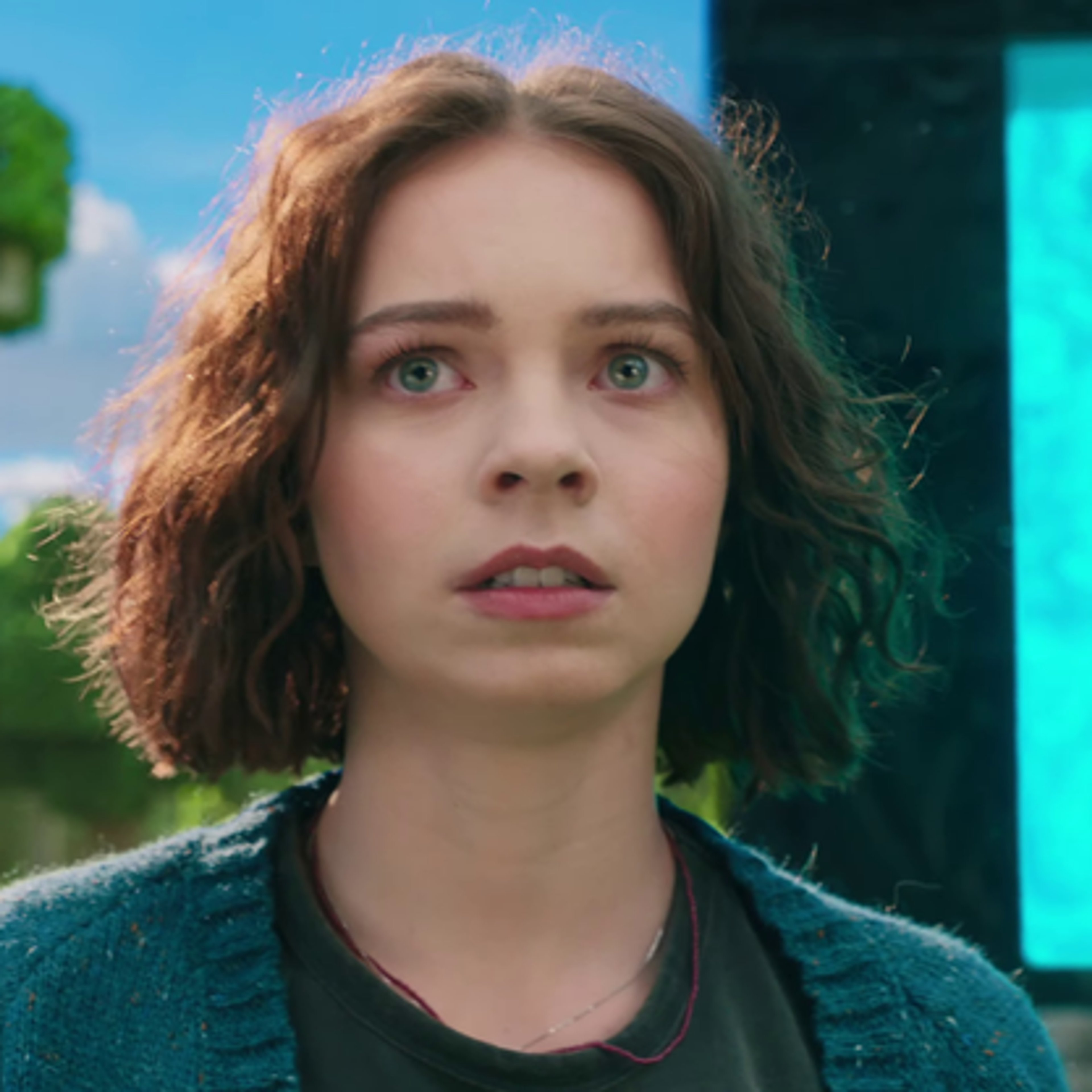 A young woman with short brown hair wearing a blue cardigan