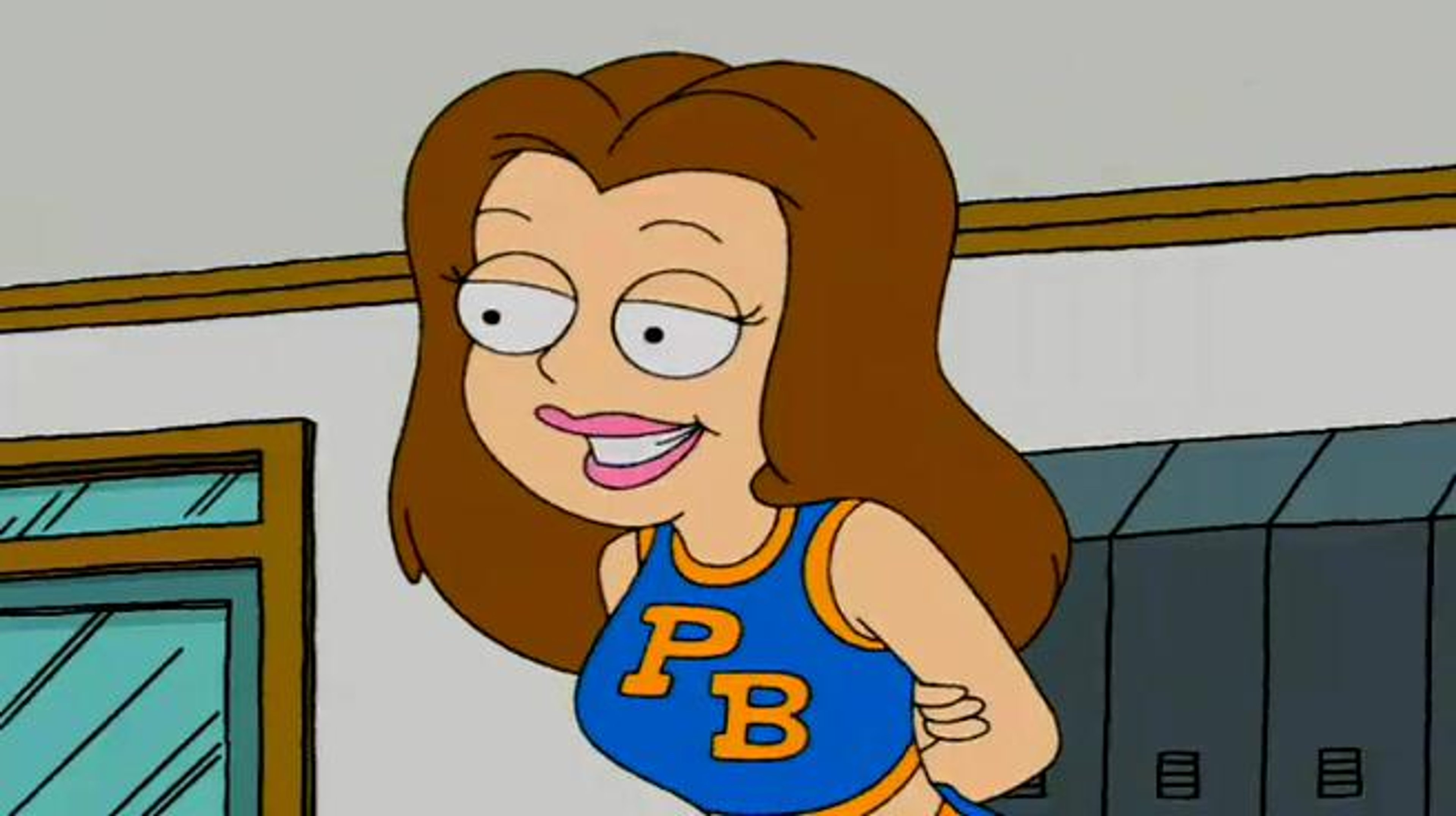 A young woman in a blue cheerleader uniform with long brown hair, smiling confidently.