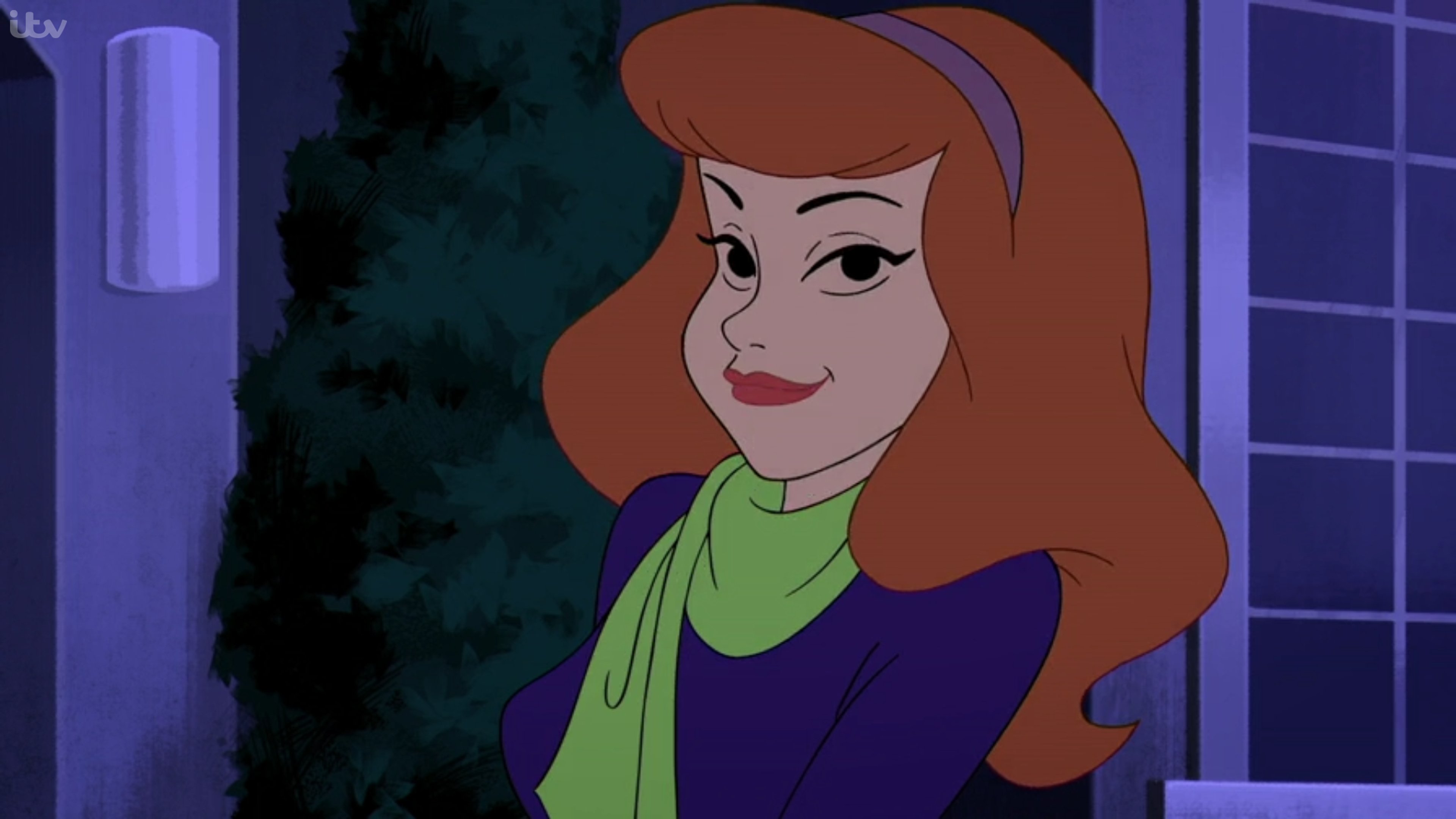 An animated female character with red hair, wearing a green sweater and purple skirt, with a friendly expression.