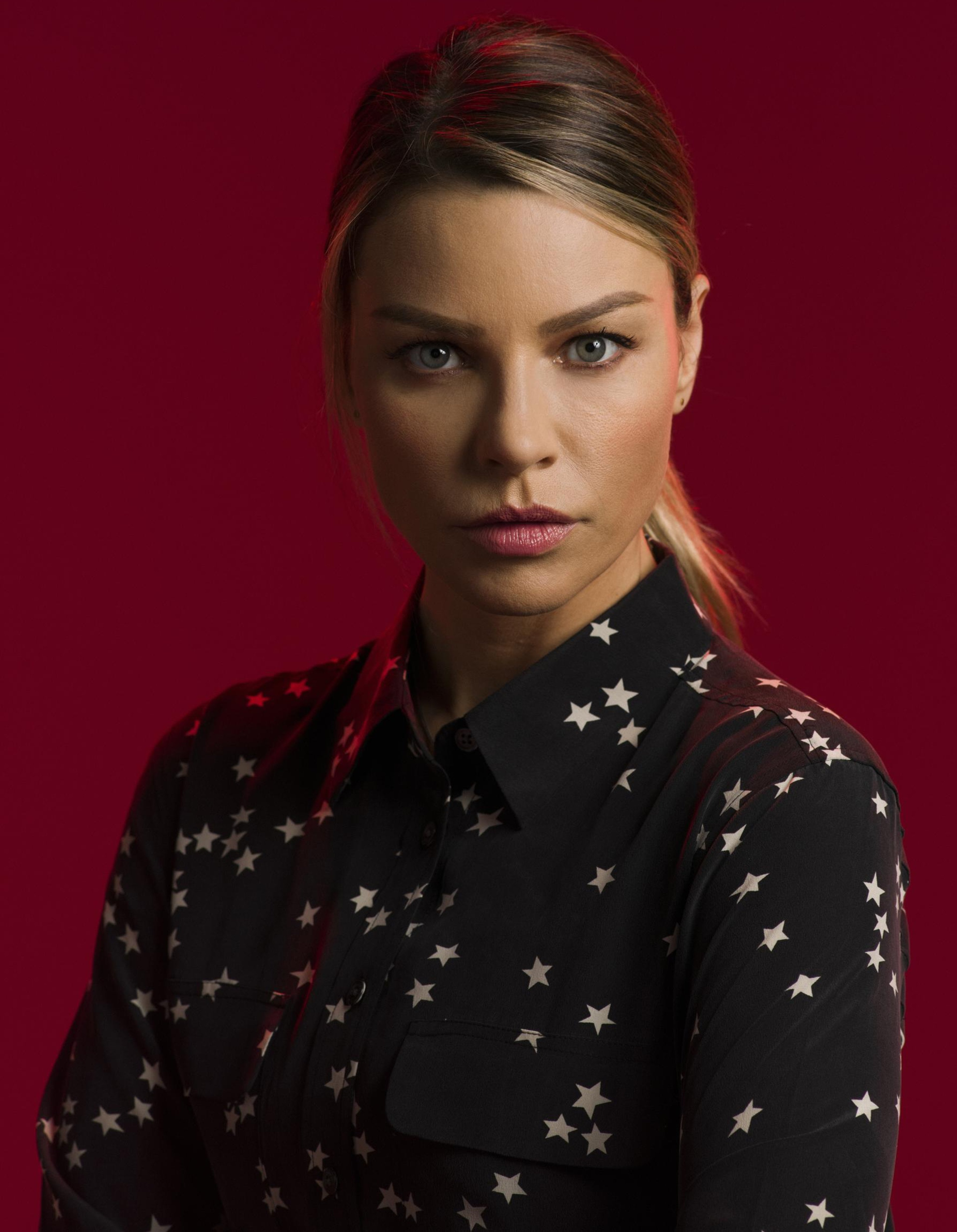 A woman with brown hair wearing a black jacket with star patterns