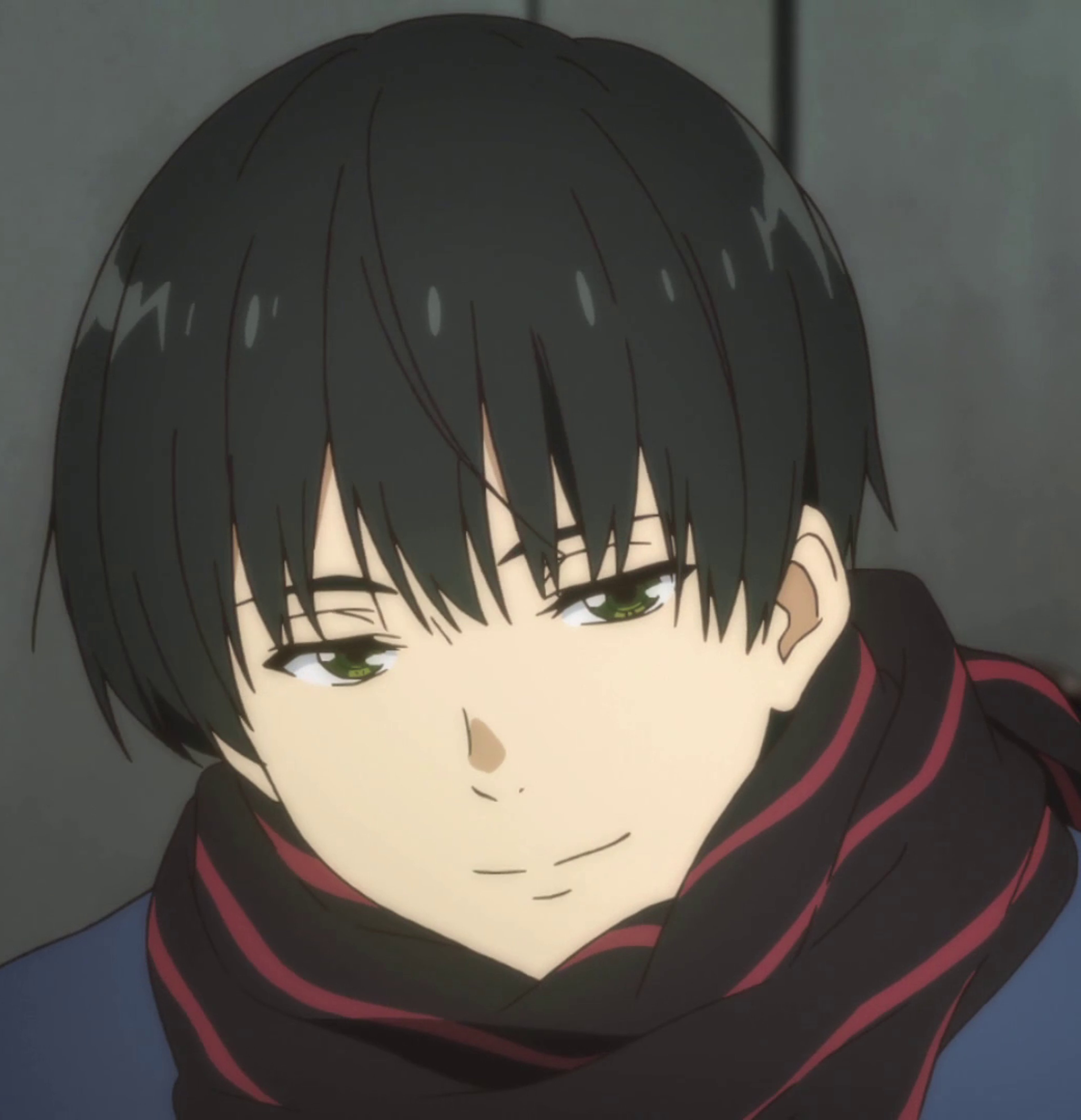 A young man with dark hair wearing a red scarf