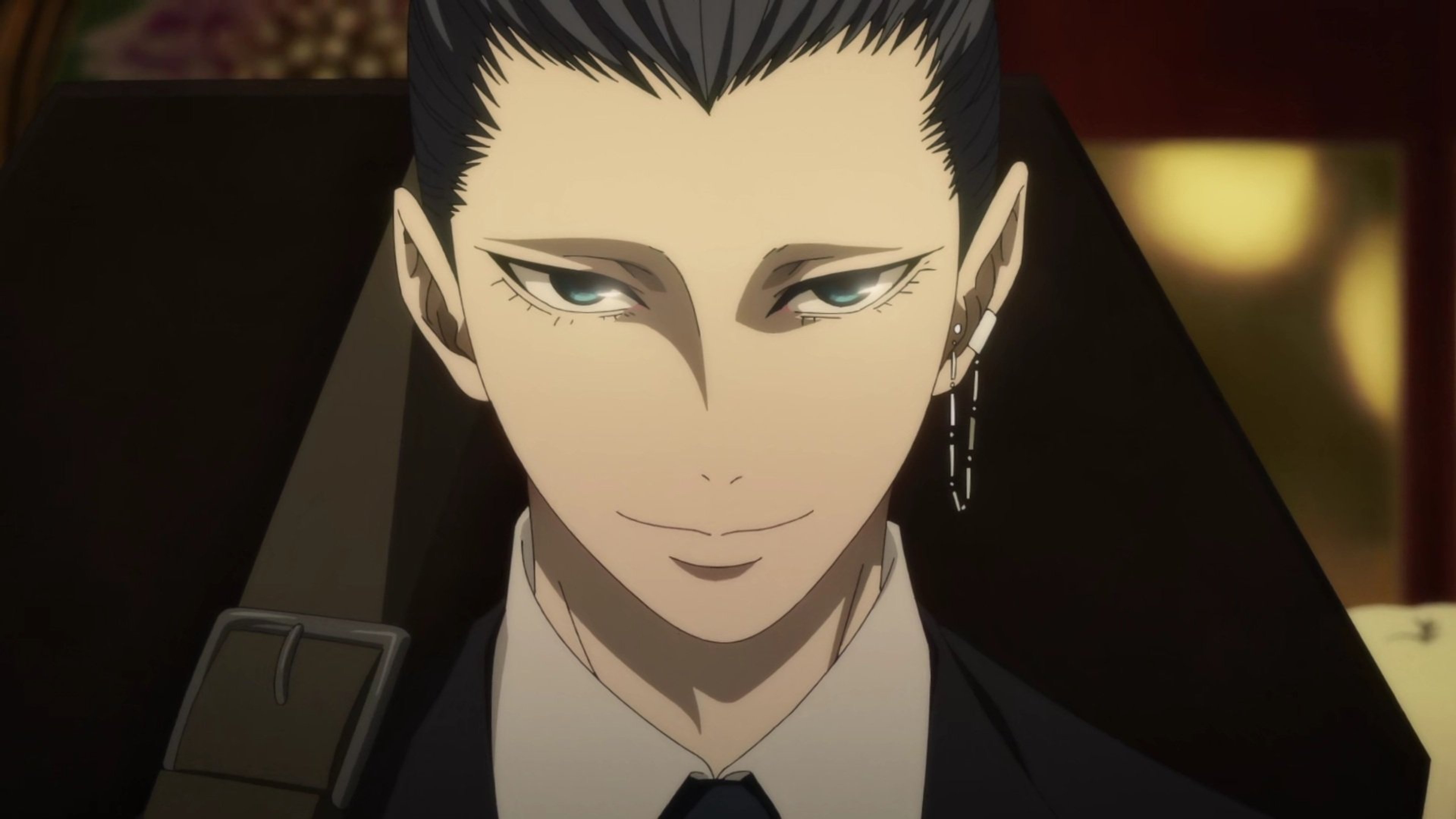 A young, stylishly dressed man with pale skin, dark eyes, and slicked-back black hair