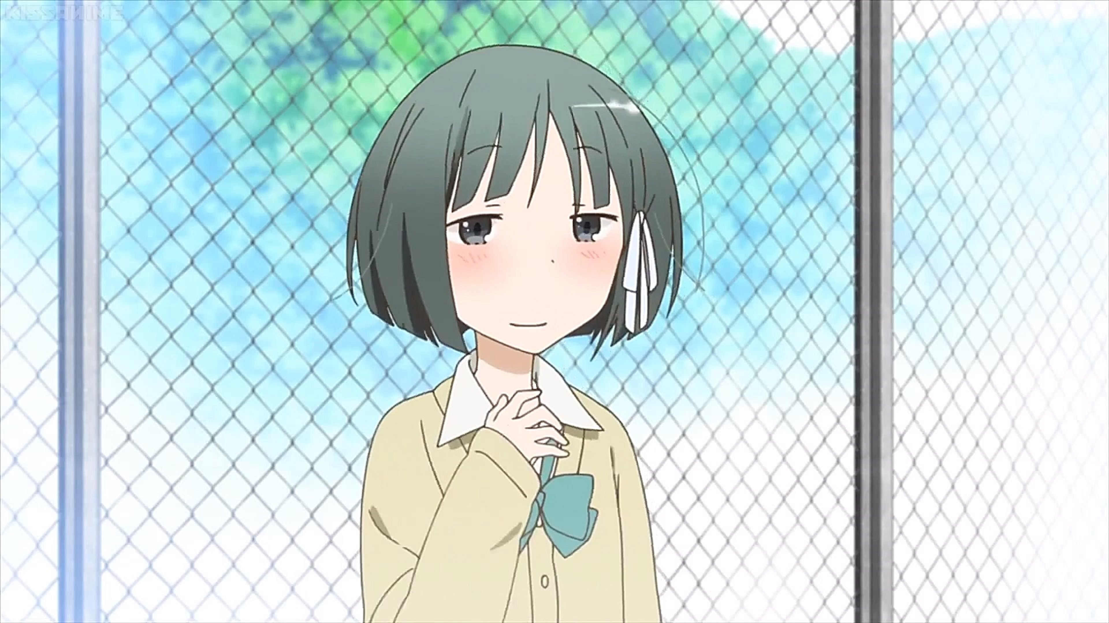 A cheerful high school girl with short dark hair wearing a school uniform
