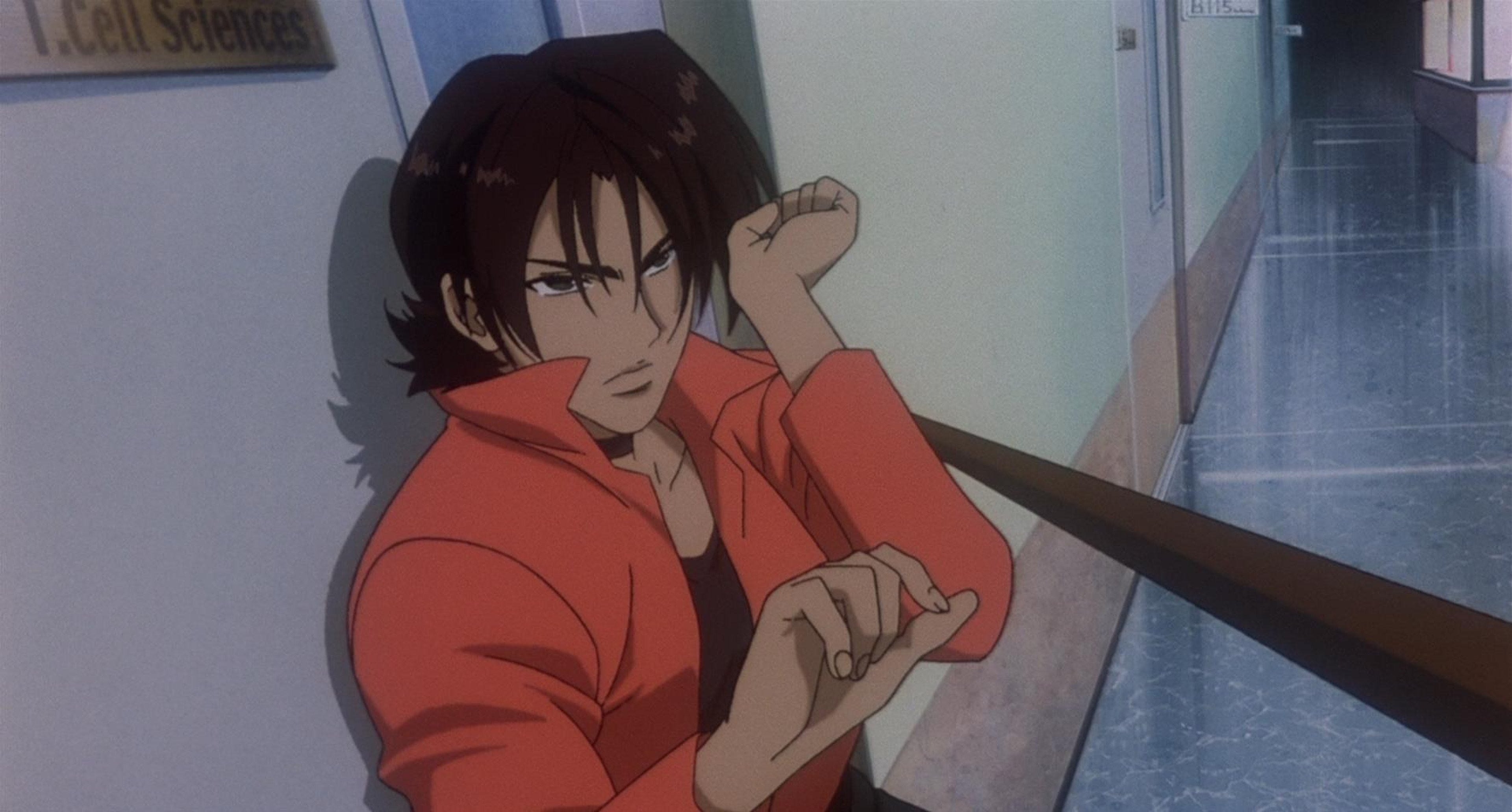 A young woman in a red jacket with a serious expression