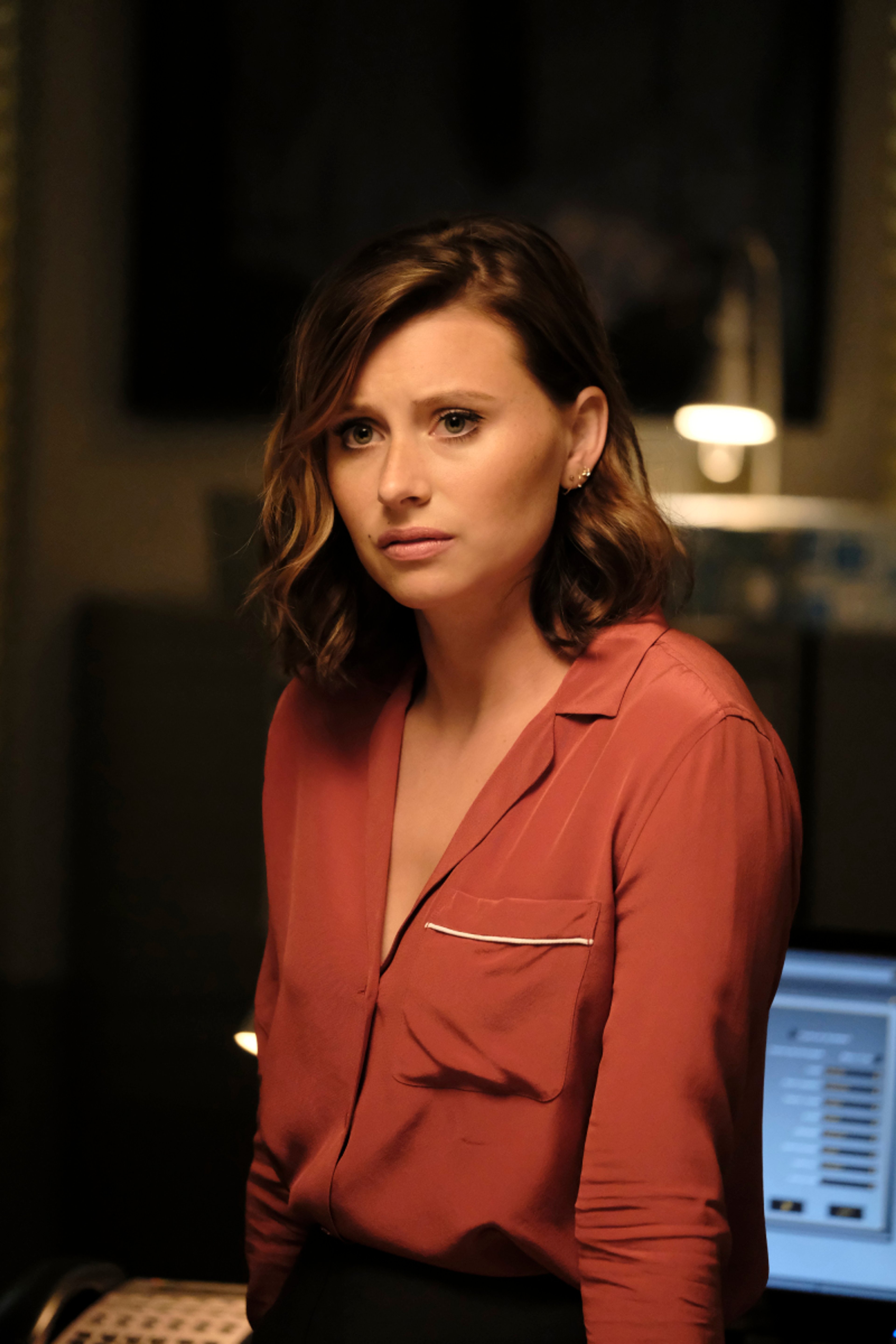 A woman with brown hair wearing a red jacket in a professional setting