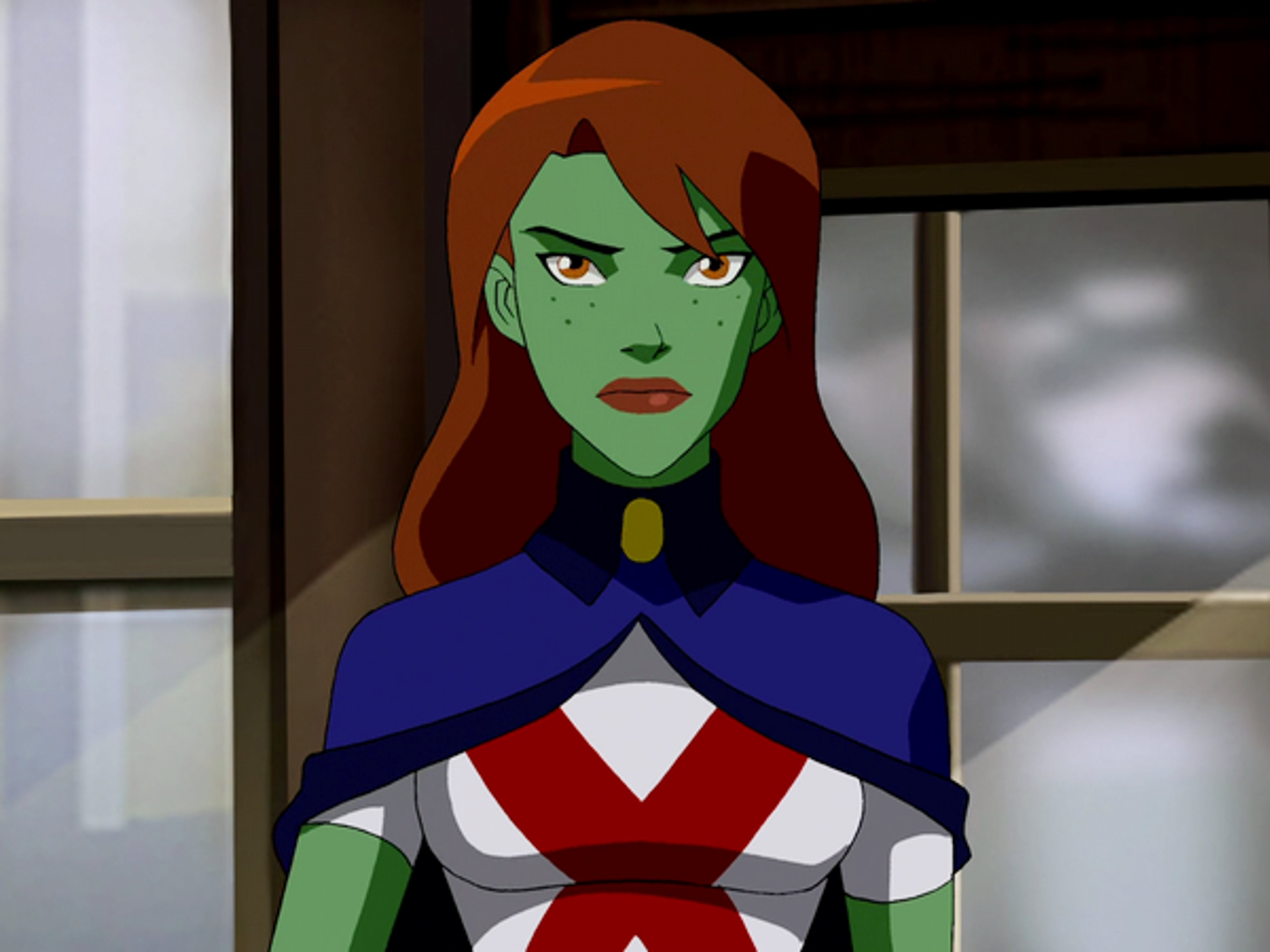 A green-skinned female superhero character with red hair and a distinctive costume