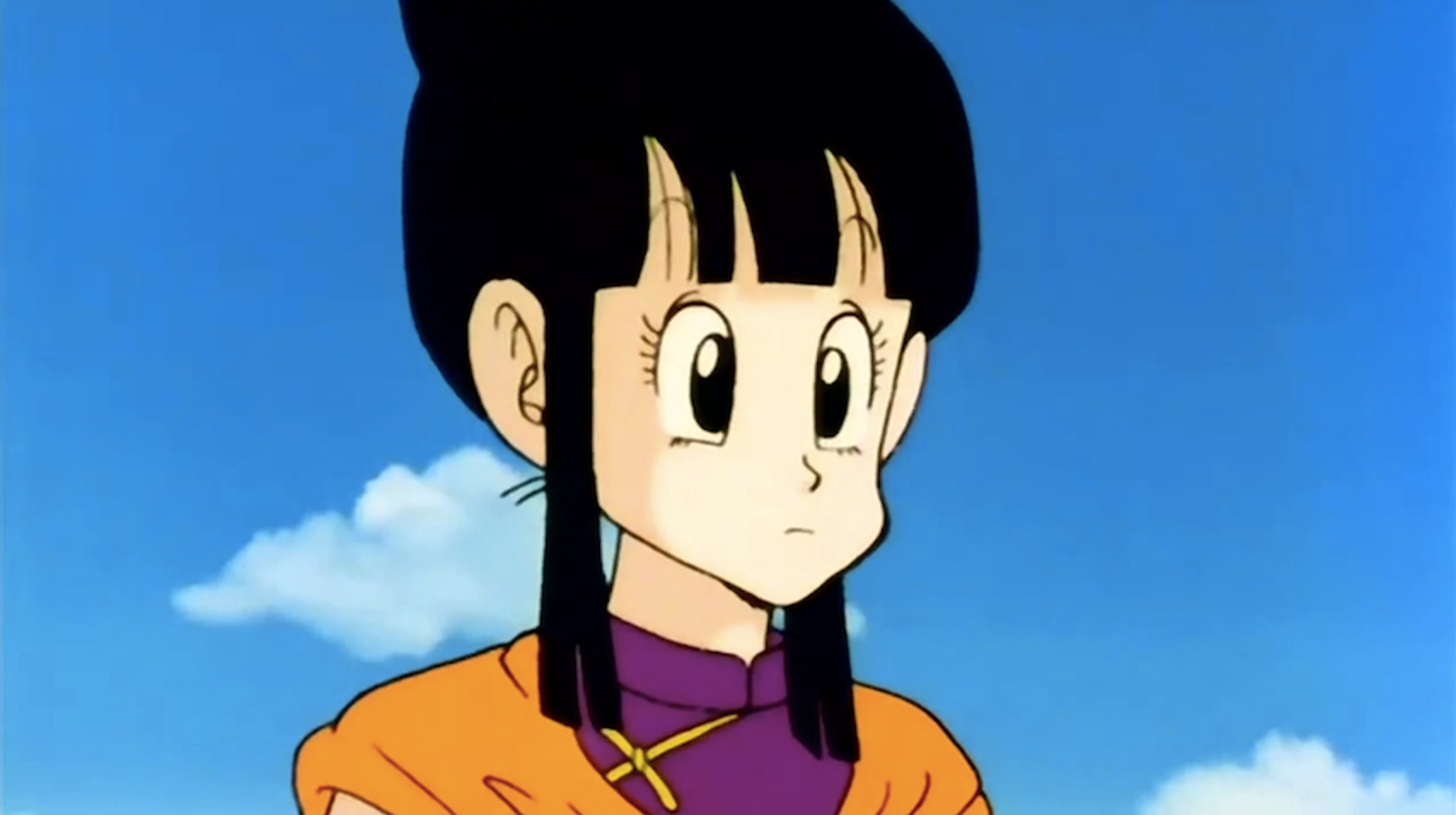 An anime-style character with large eyes, a round face, and short dark hair wearing an orange outfit with a purple sash.