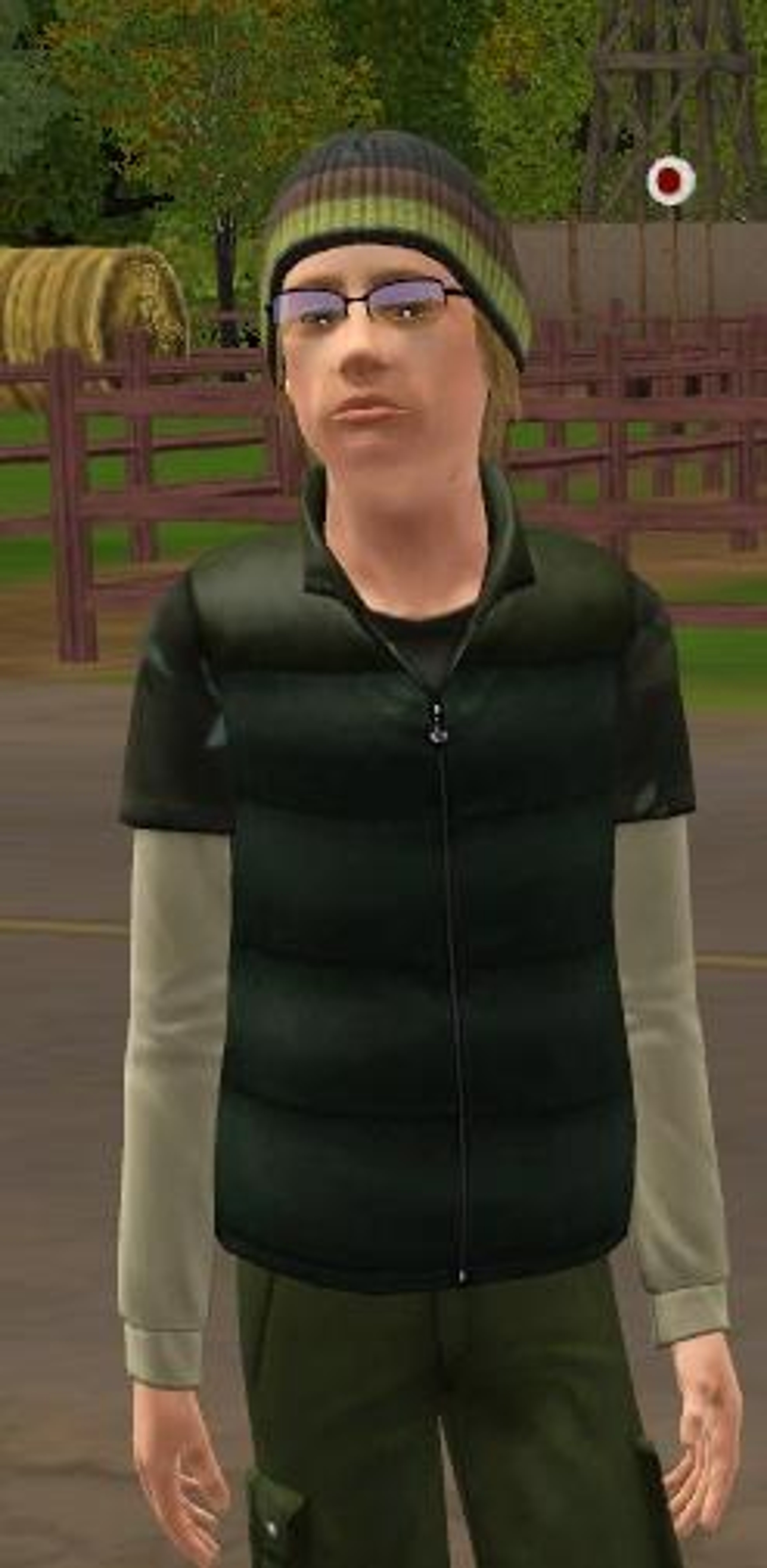 A young man with a grumpy expression wearing a green jacket and beanie hat