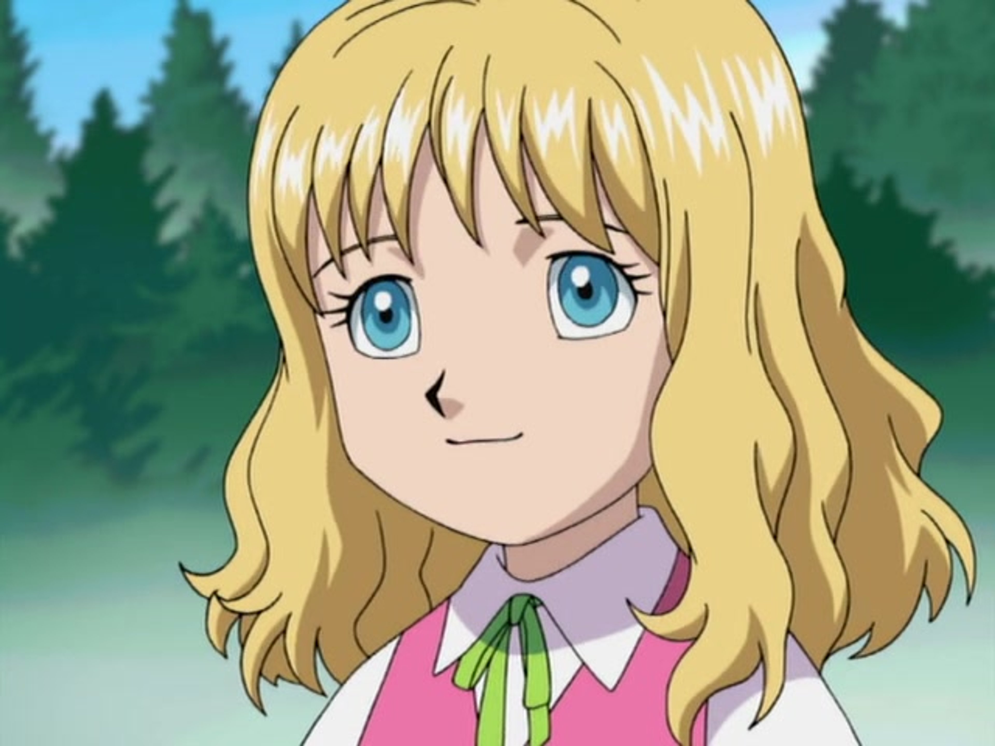 A young woman with blonde hair and bangs, sitting in a wheelchair in a forested area.