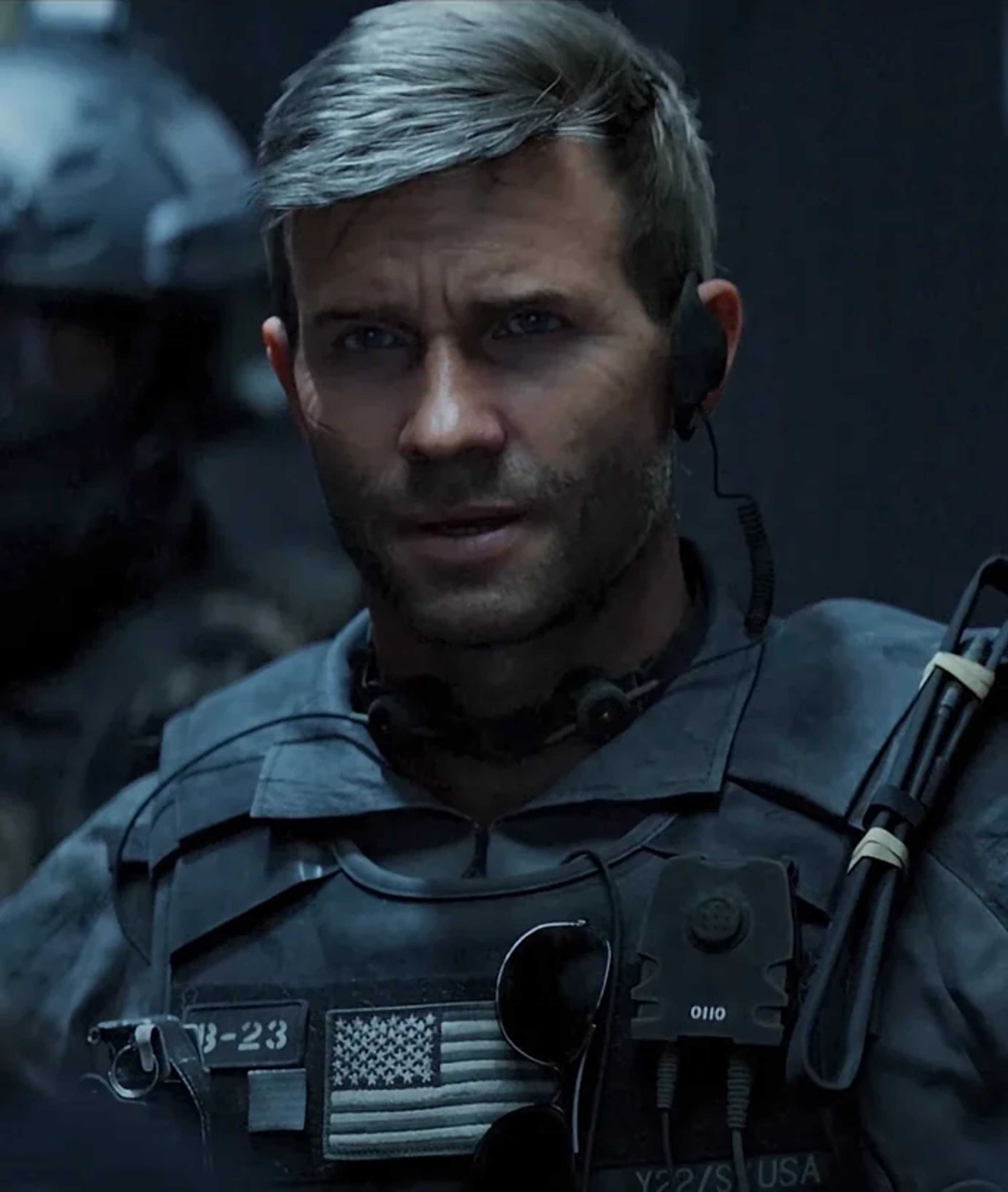 A military commander with a stern, intense expression wearing tactical gear