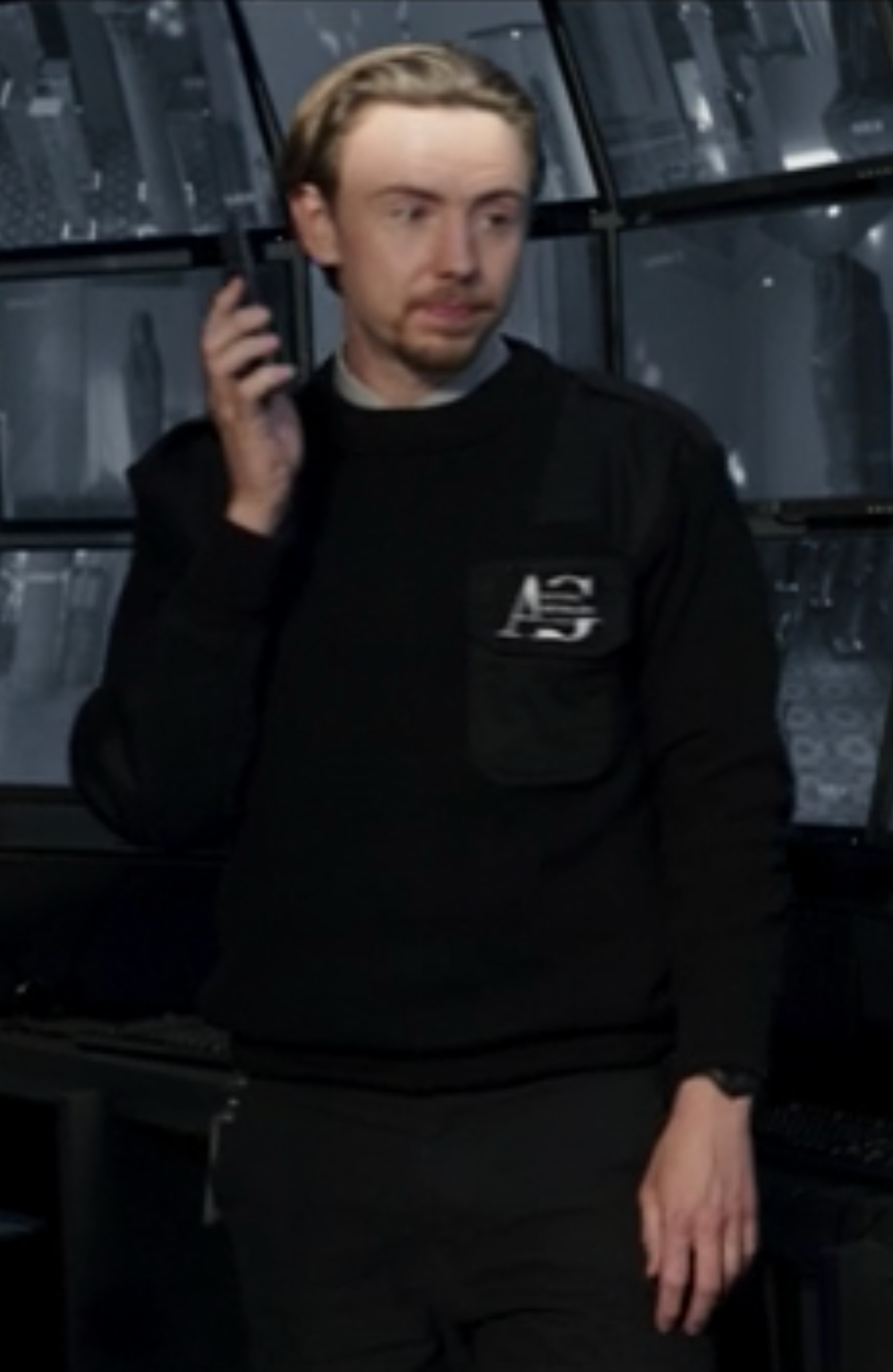 A man with short blonde hair wearing a black sweater