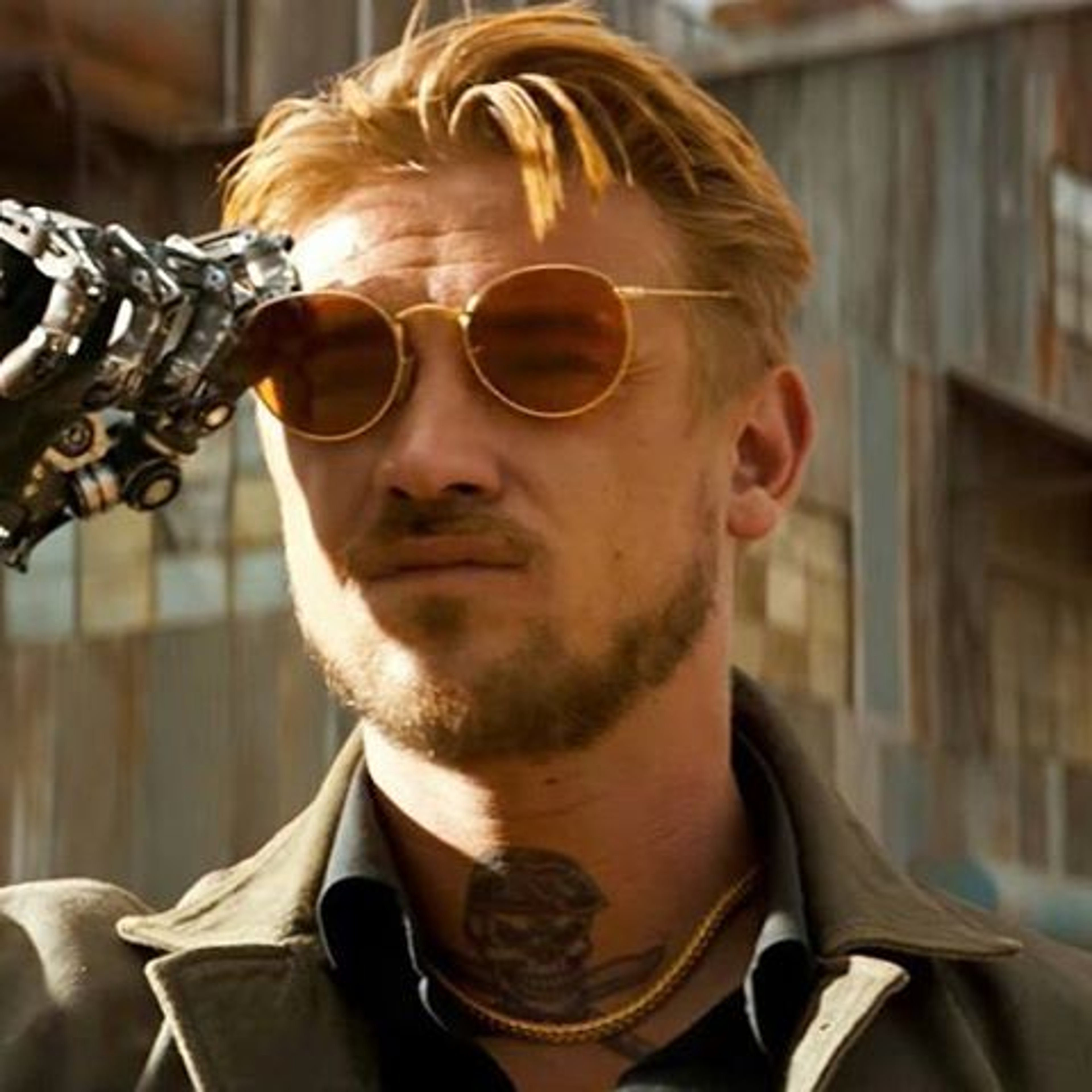 A man with a cybernetic arm wearing sunglasses and a leather jacket