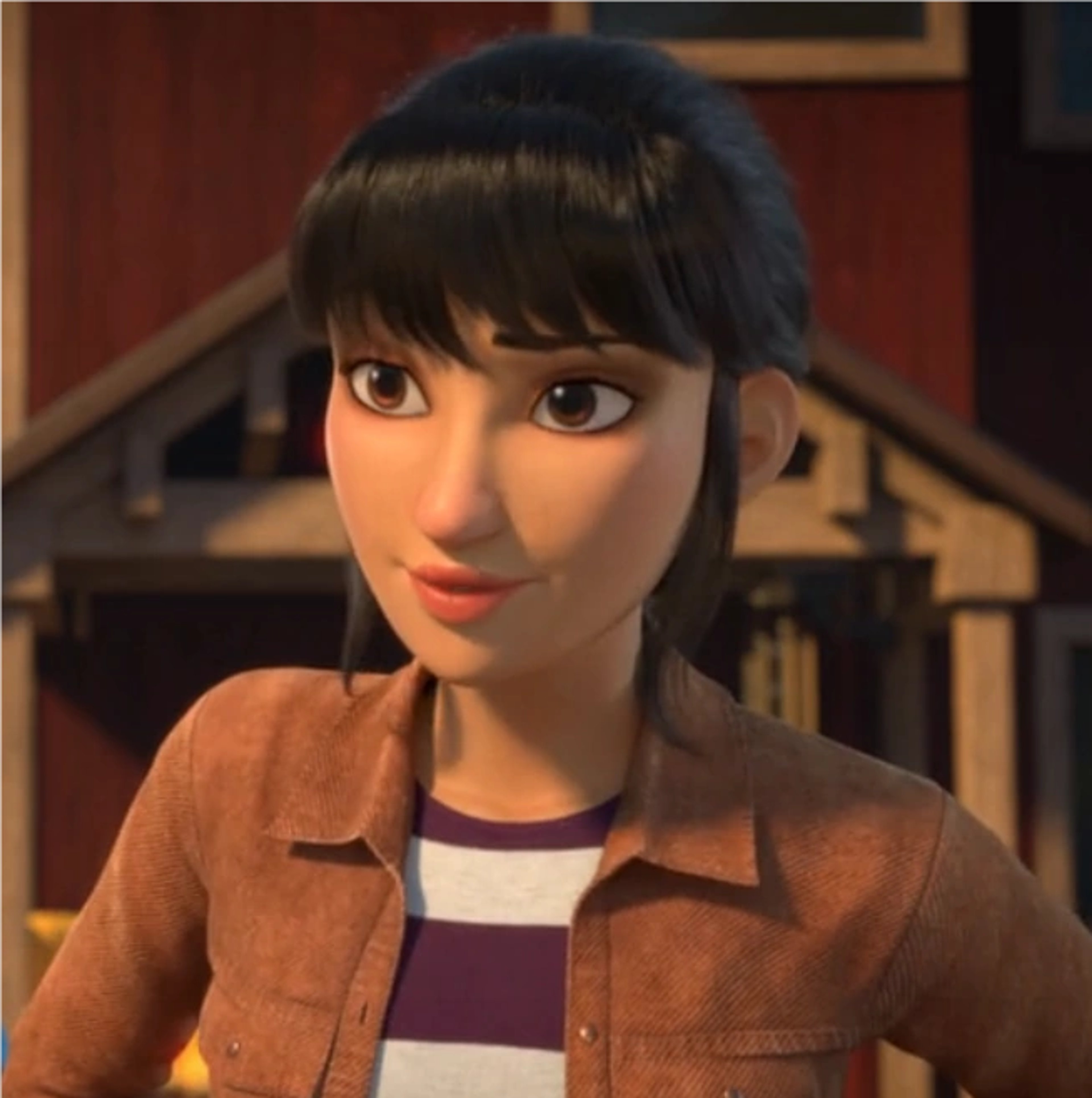 A young woman with short dark hair and bangs, wearing a brown jacket over a striped shirt, with a friendly expression on her face.