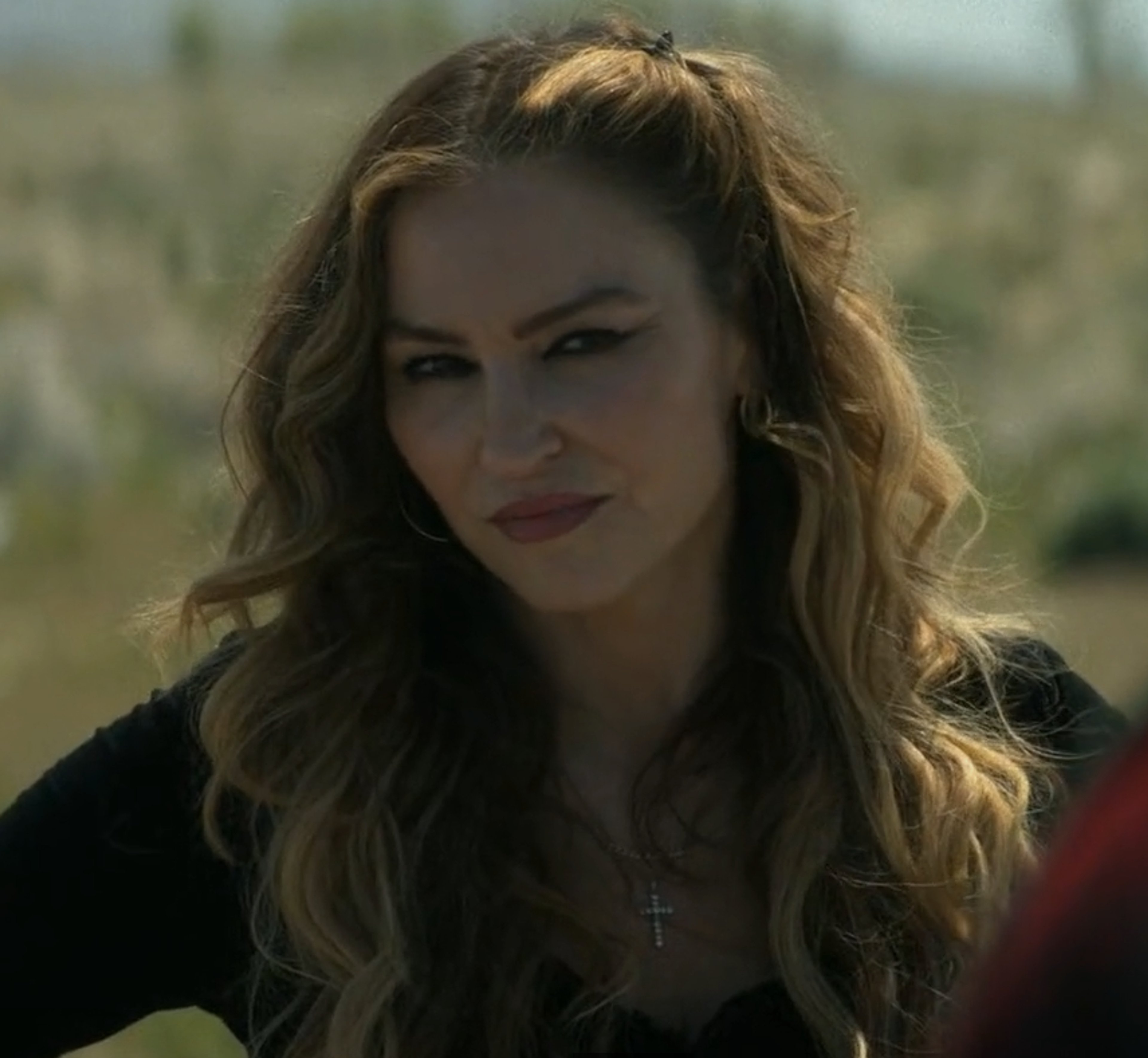 A woman with long brown hair wearing a black leather jacket