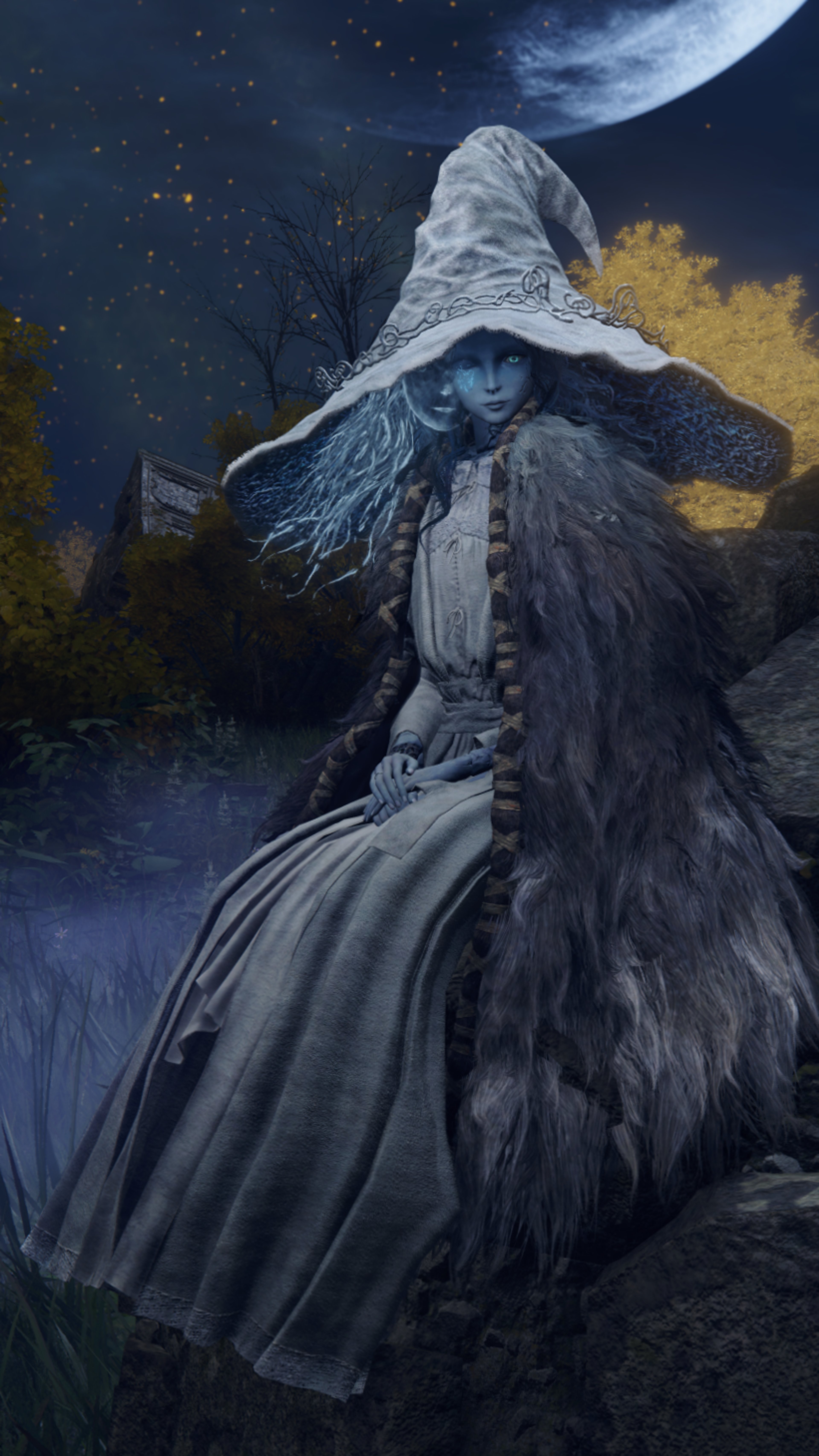 A mysterious blue-skinned witch-like character standing in a dark forest at night