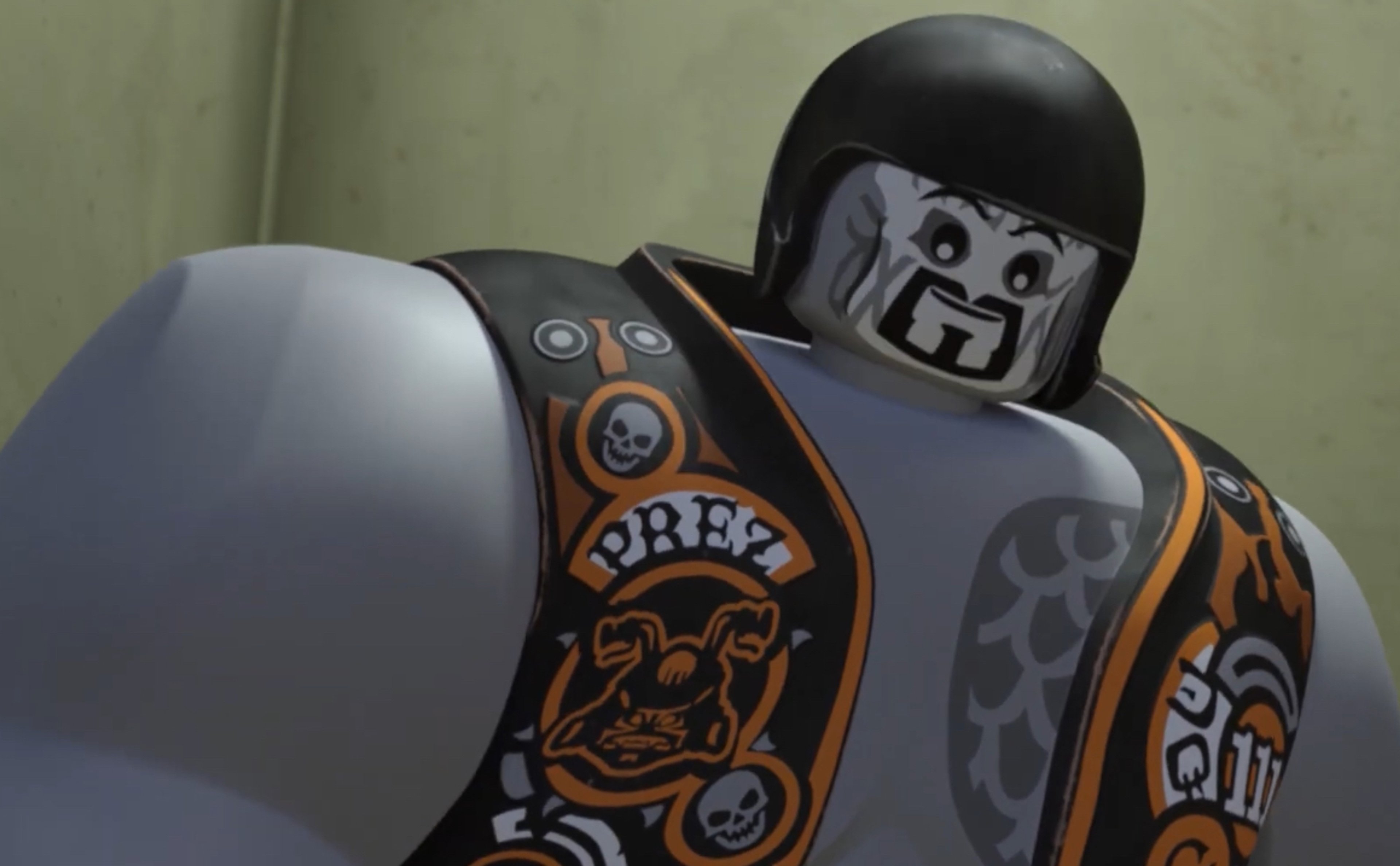 A large, muscular gray-skinned figure with extensive tattoos and a black helmet with a skull-like design