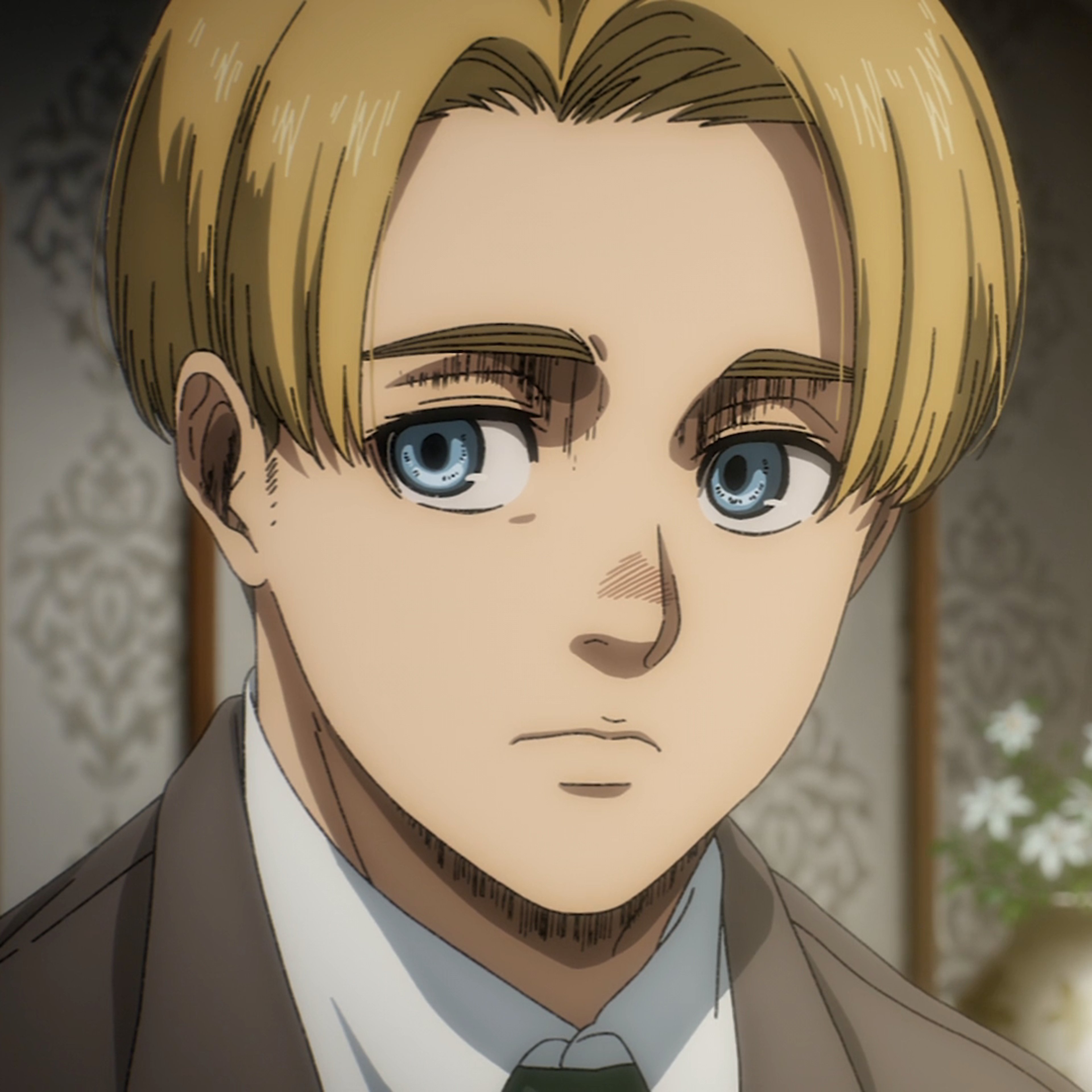 A young blond man in a suit and tie with a serious expression