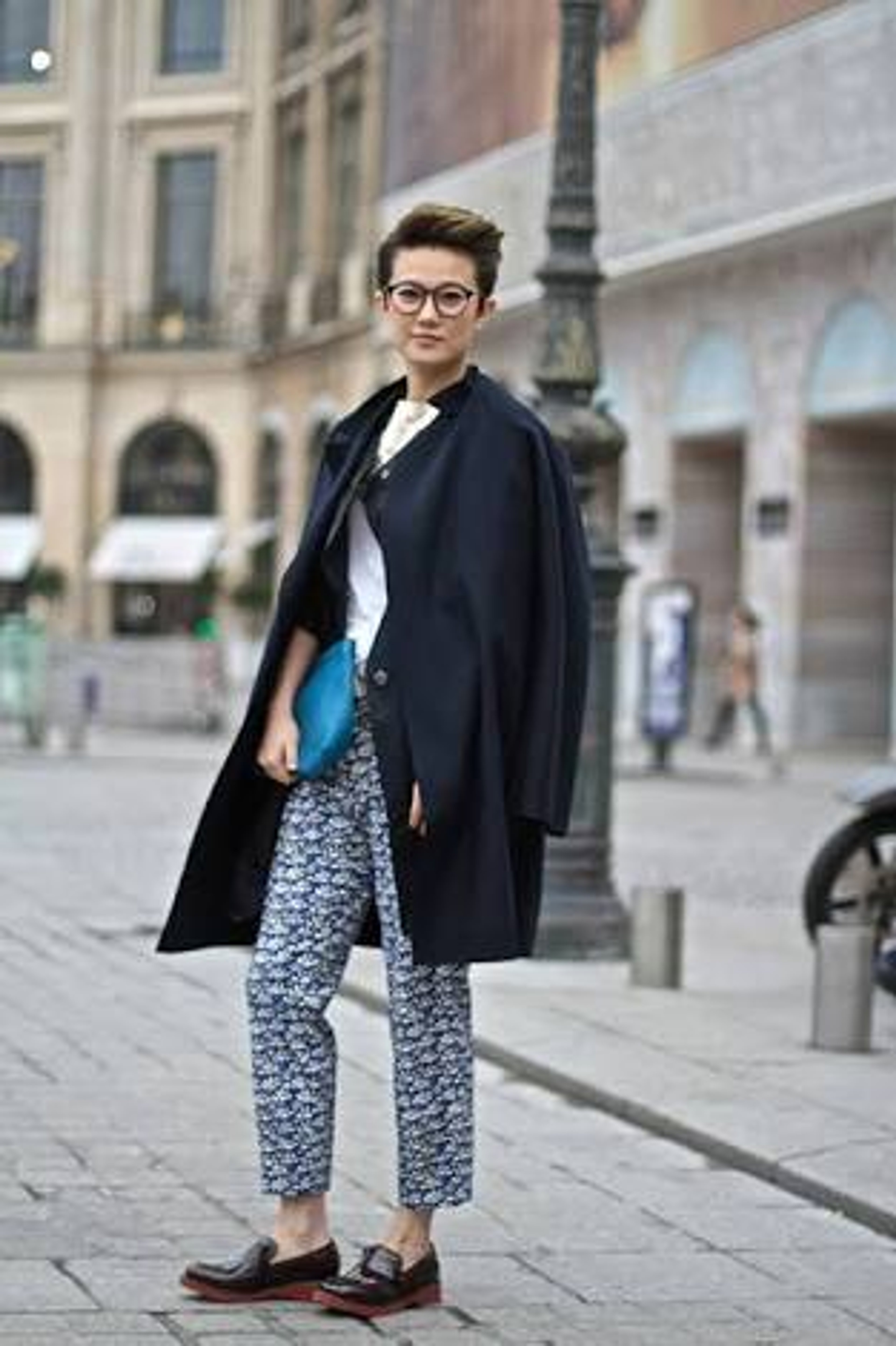 A person with an androgynous appearance standing in an urban setting