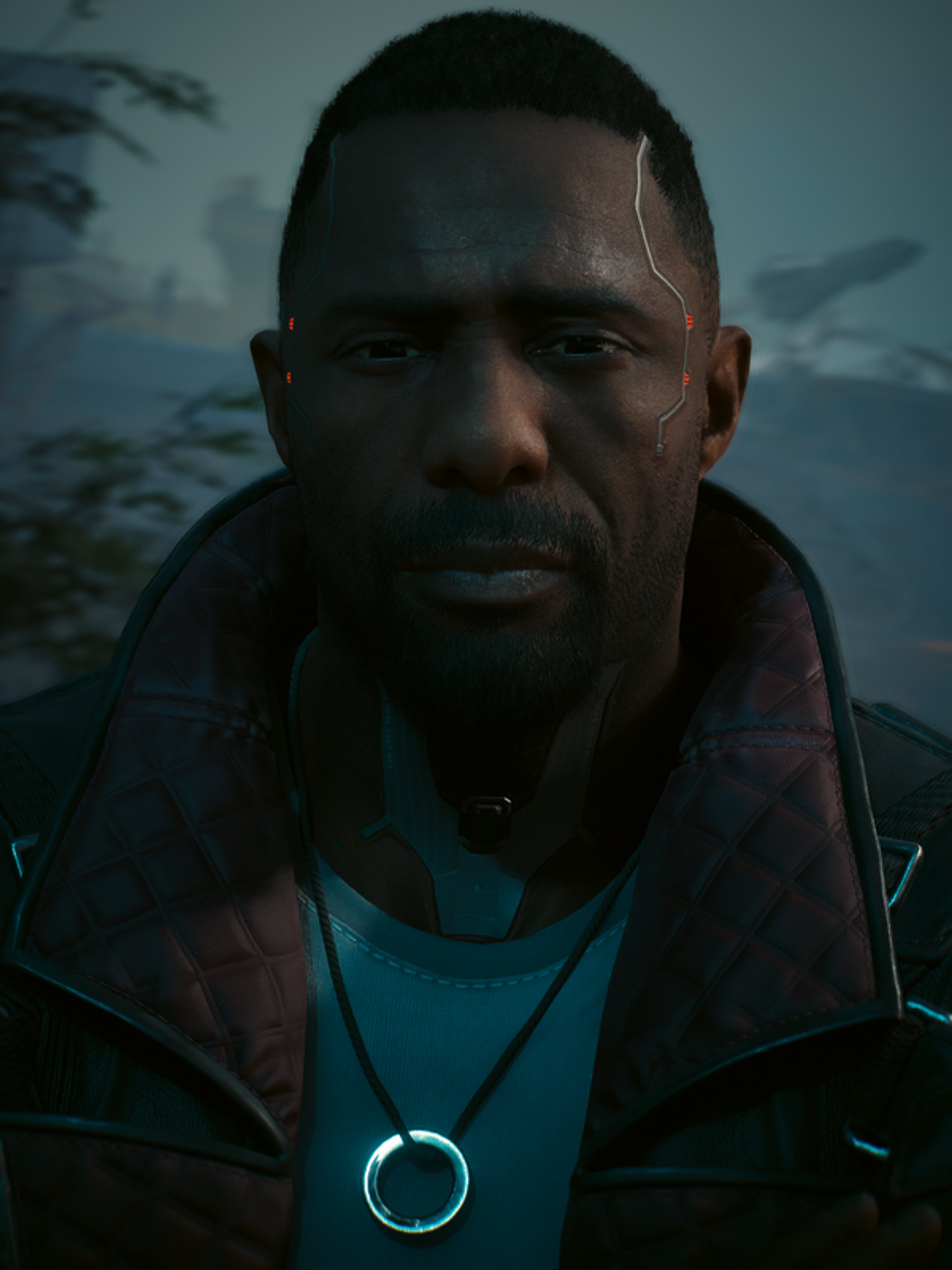 A middle-aged Black man with a serious expression, wearing a dark jacket and teal shirt.