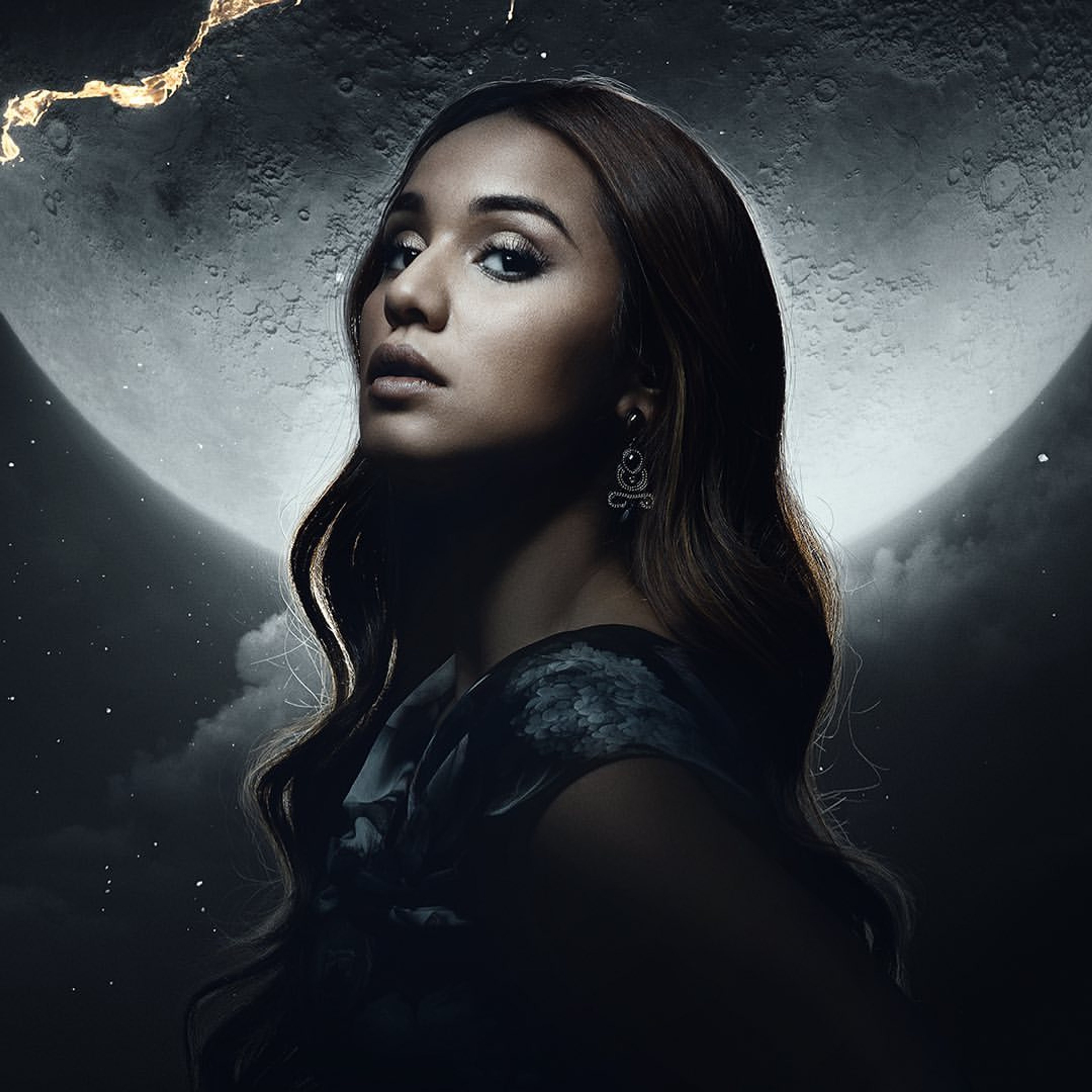 A woman with dark hair wearing a black dress in a dramatic, moonlit setting