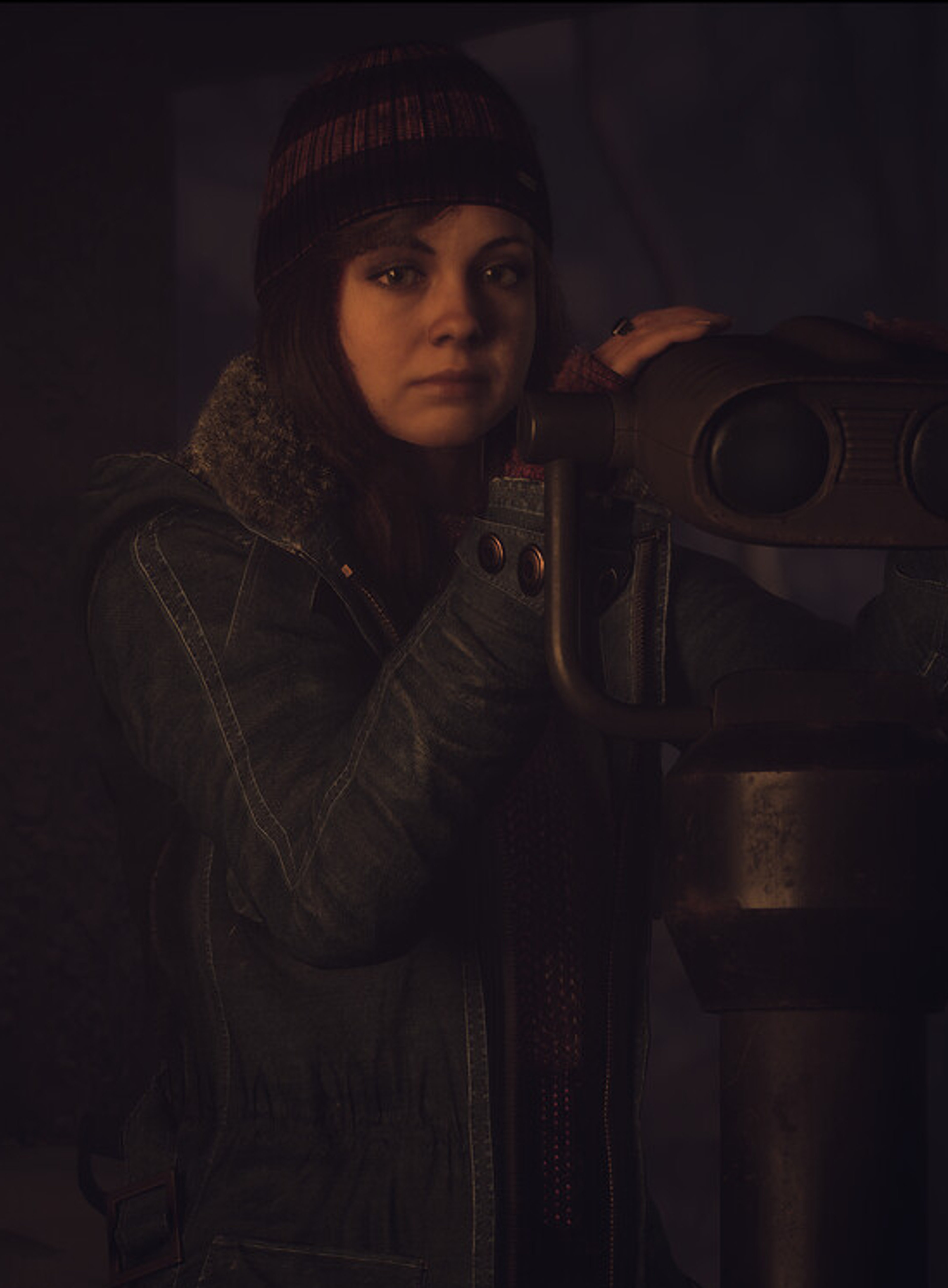 A young woman holding a camera or video equipment in a dark, moody setting.