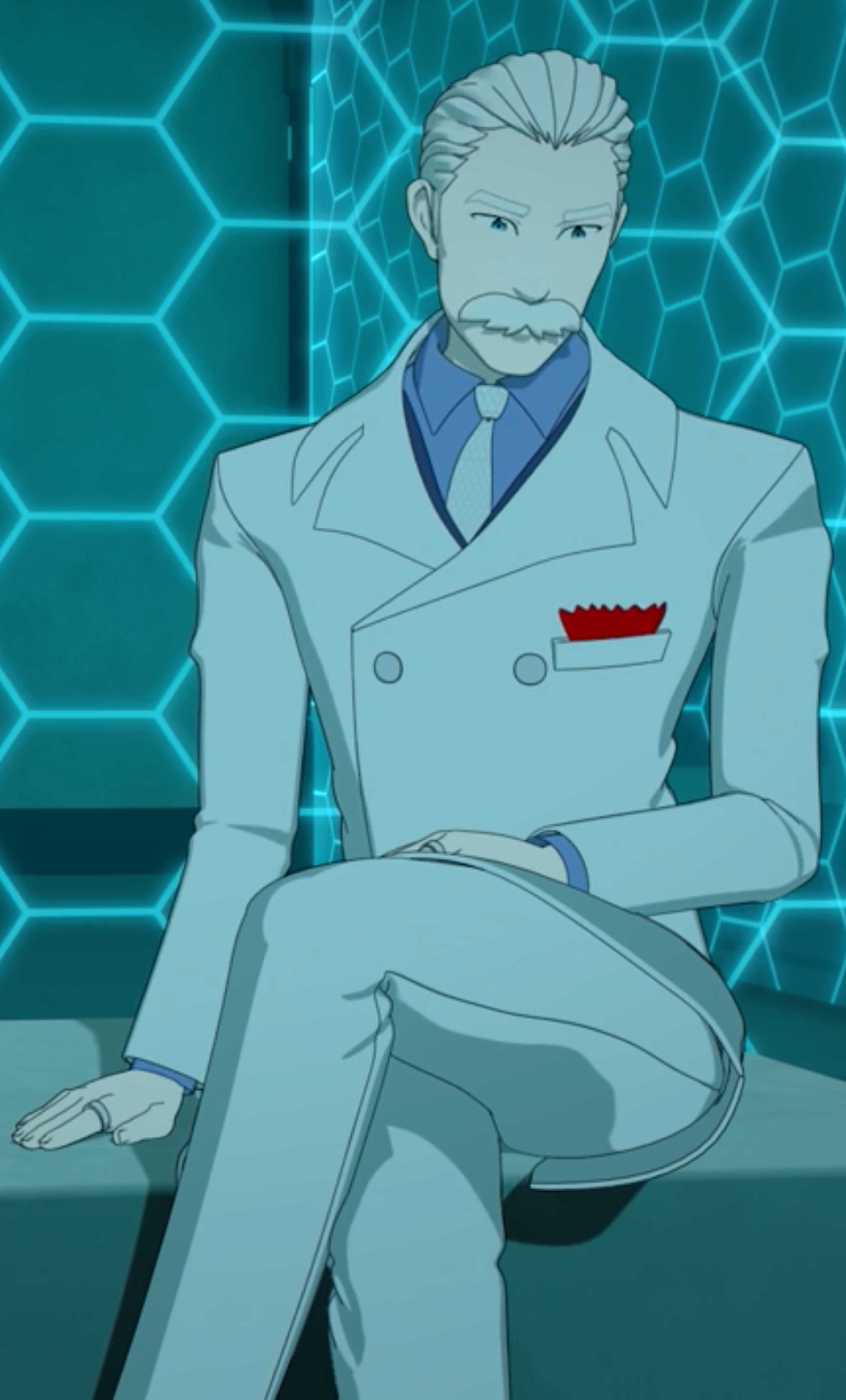 A middle-aged man in a white suit and blue tie sitting in a chair against a blue hexagonal backdrop