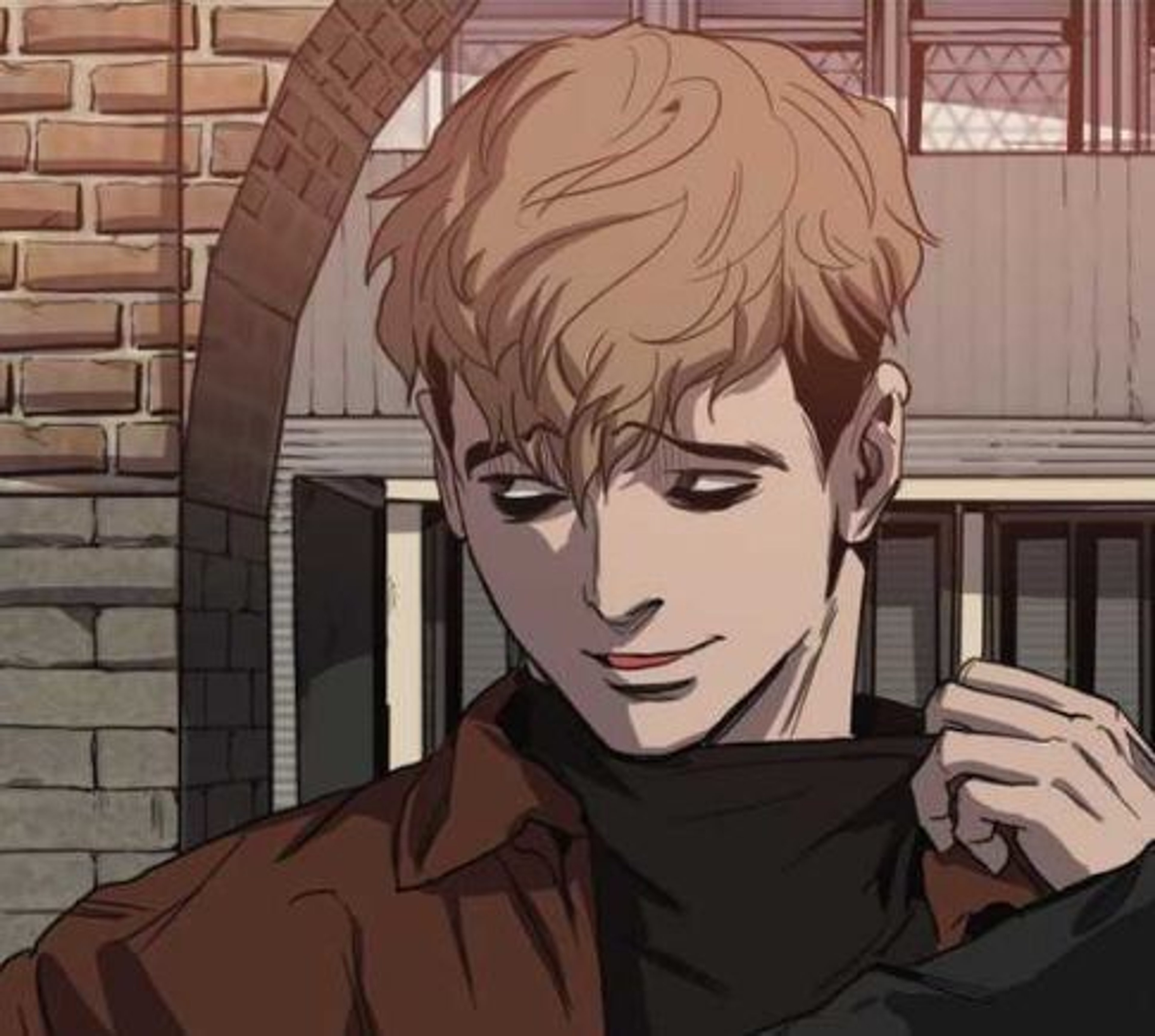 A young man with blonde hair wearing a black turtleneck sweater in a brick and wood setting