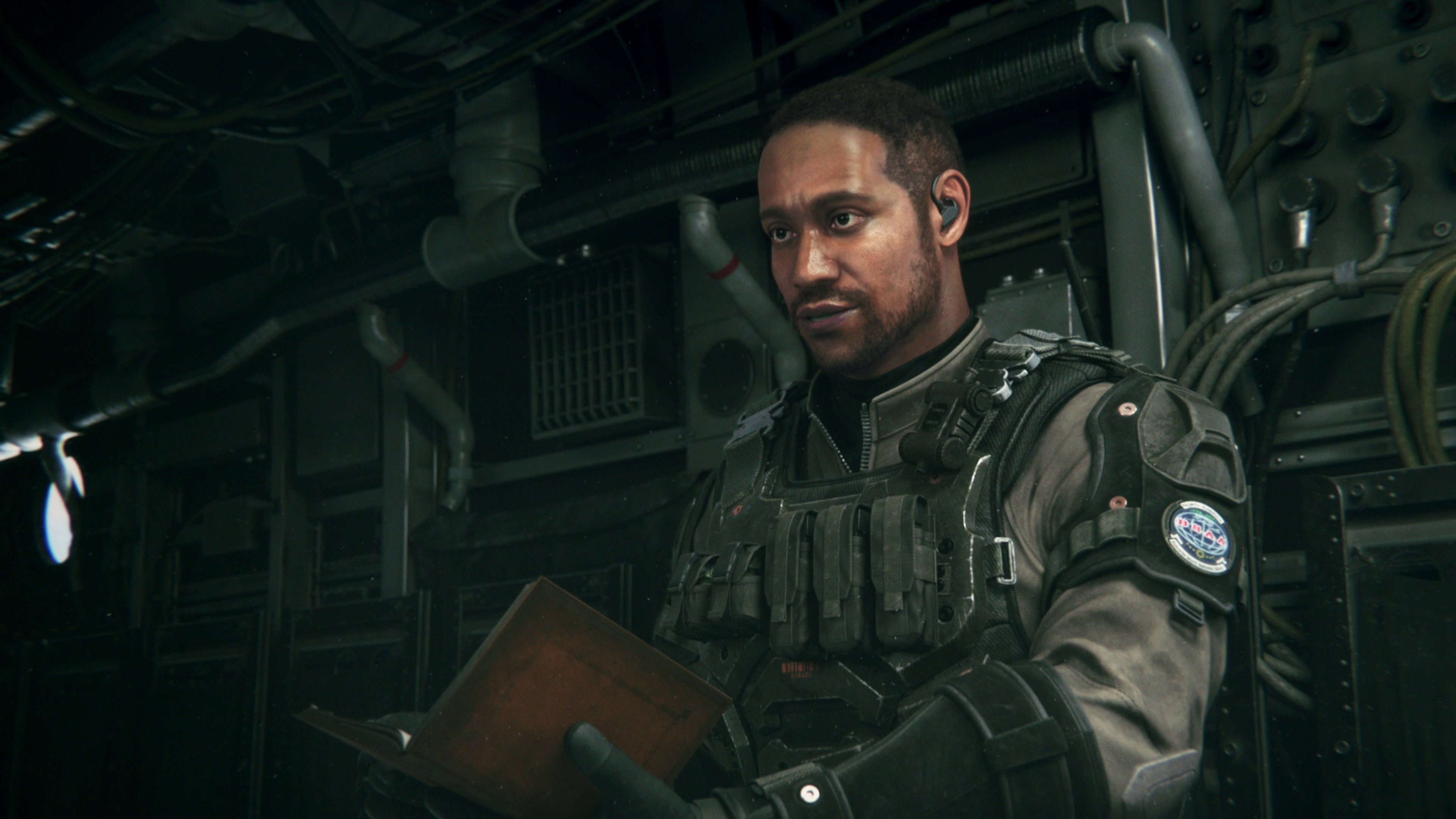 A man in military gear holding a firearm in a combat-ready stance.