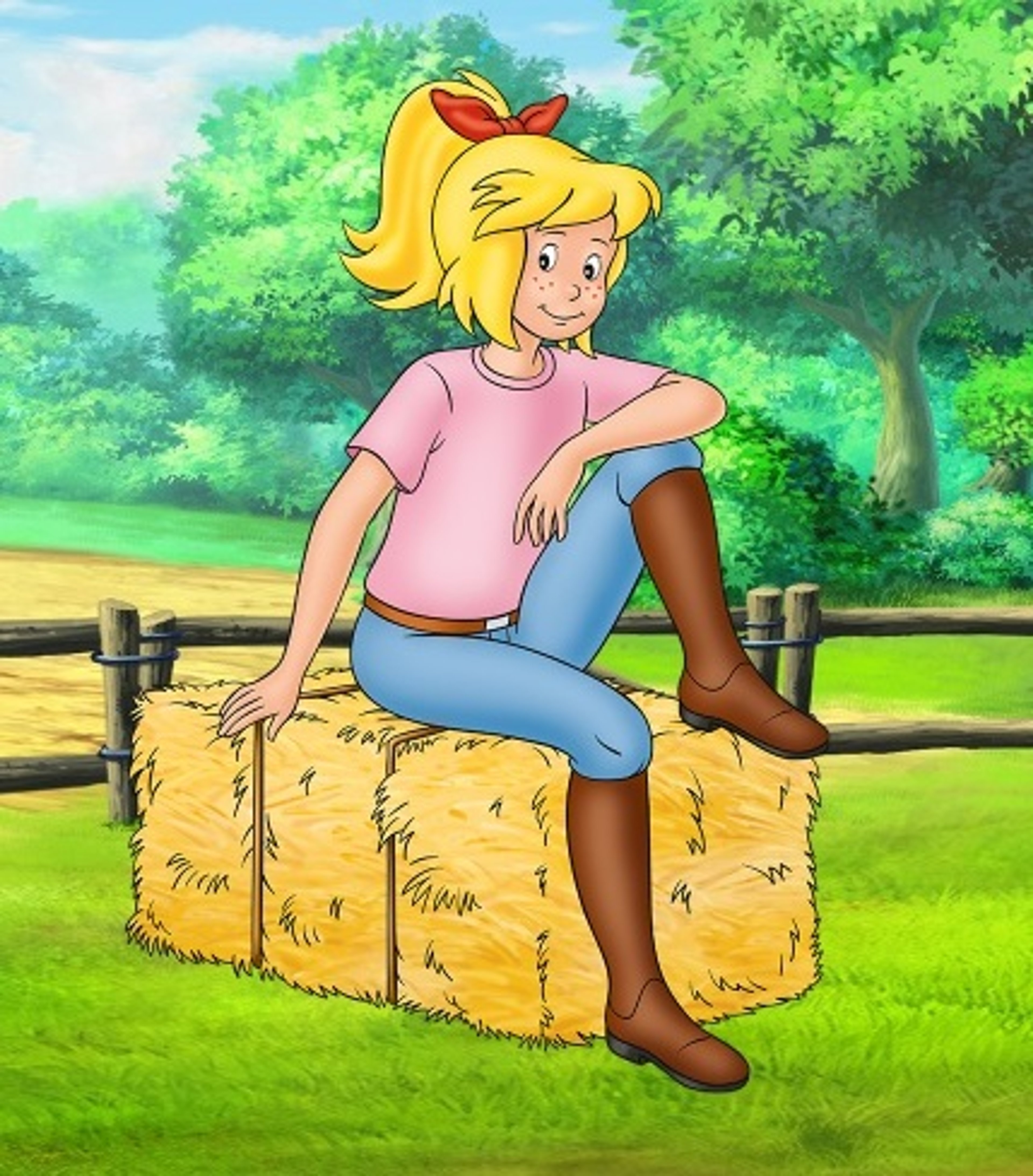 A young blonde girl sitting on a hay bale in a grassy outdoor setting