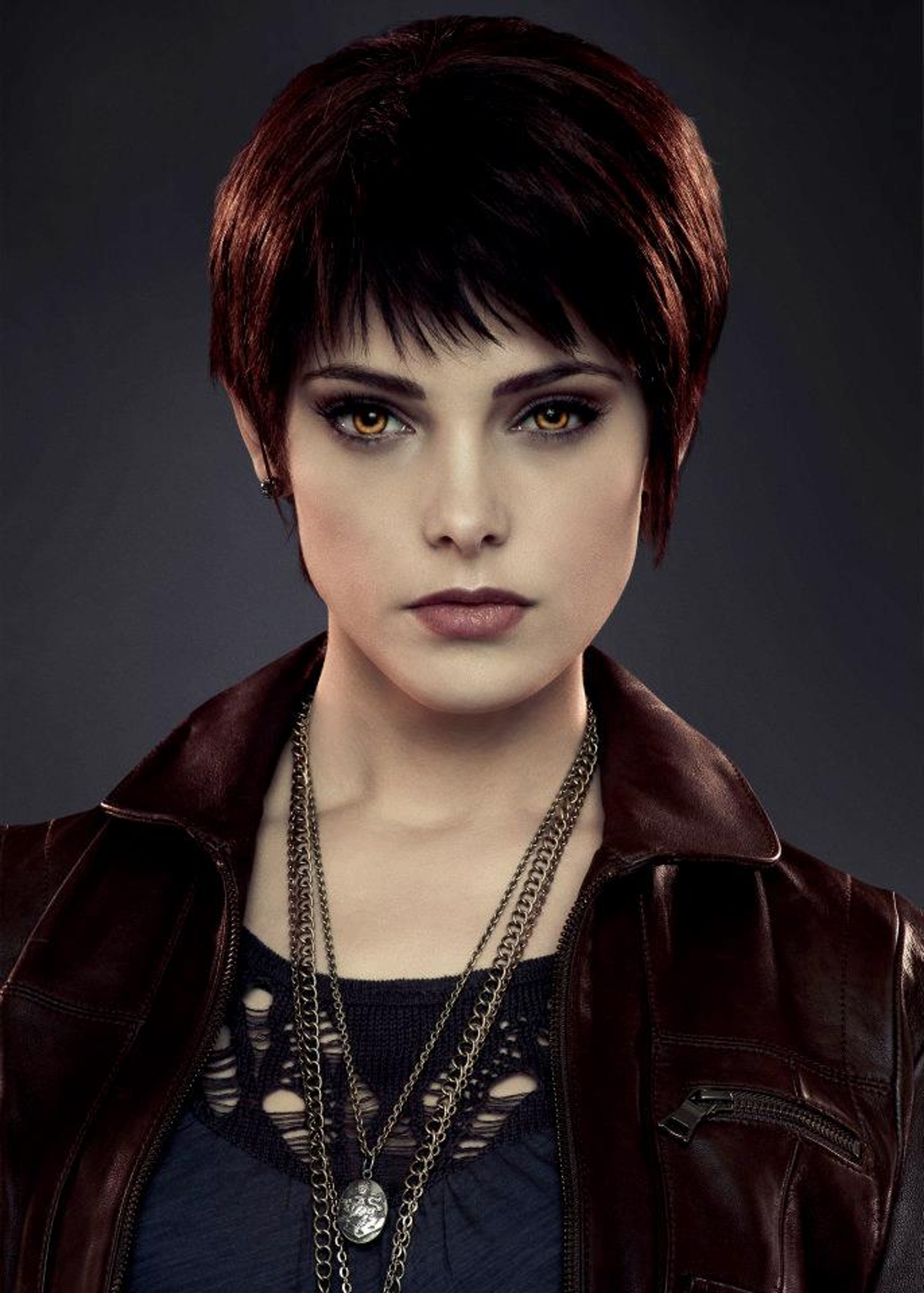 A young woman with short black hair and a serious expression, wearing a dark leather jacket.