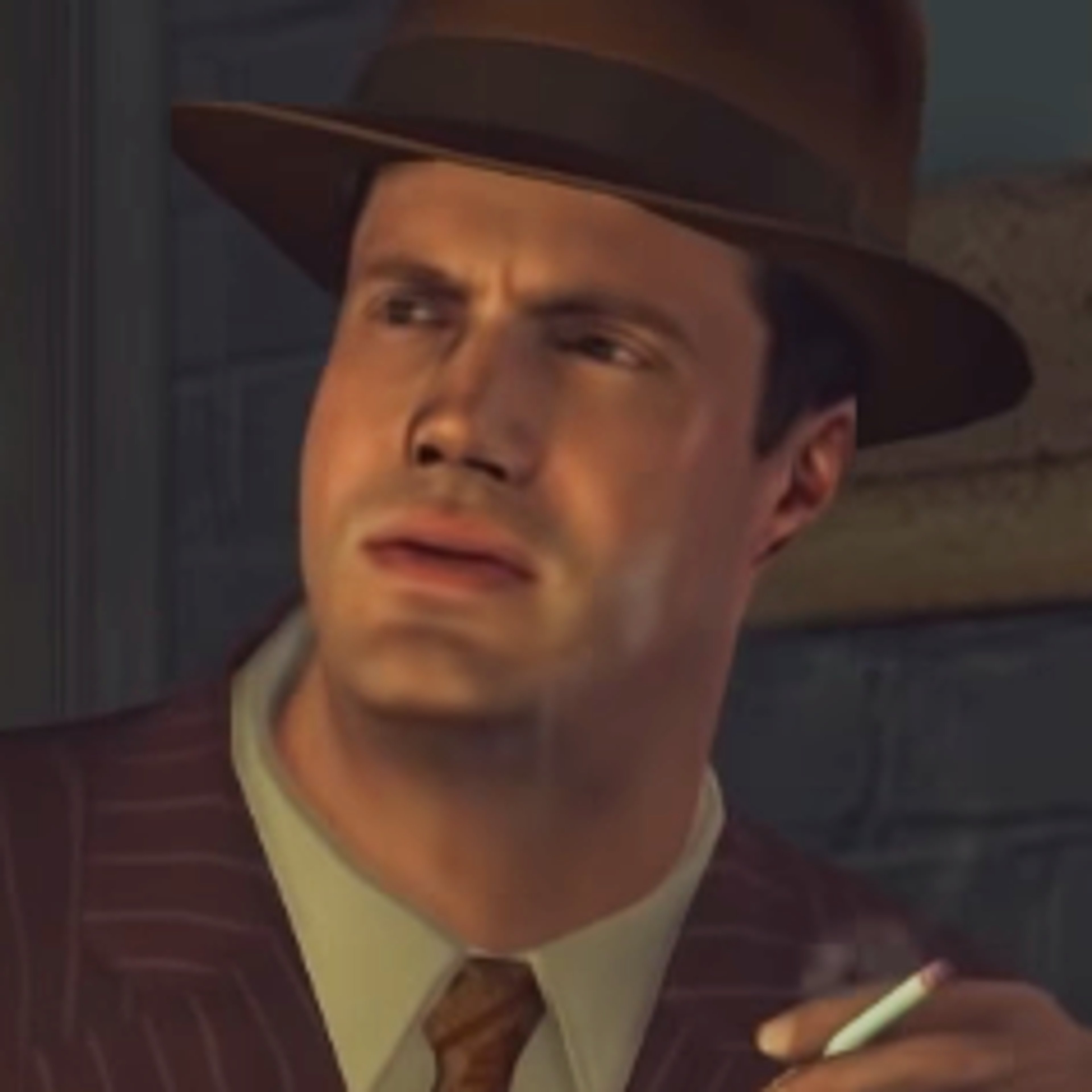 A middle-aged man with a serious expression, wearing a brown fedora hat, white collared shirt, and dark tie.