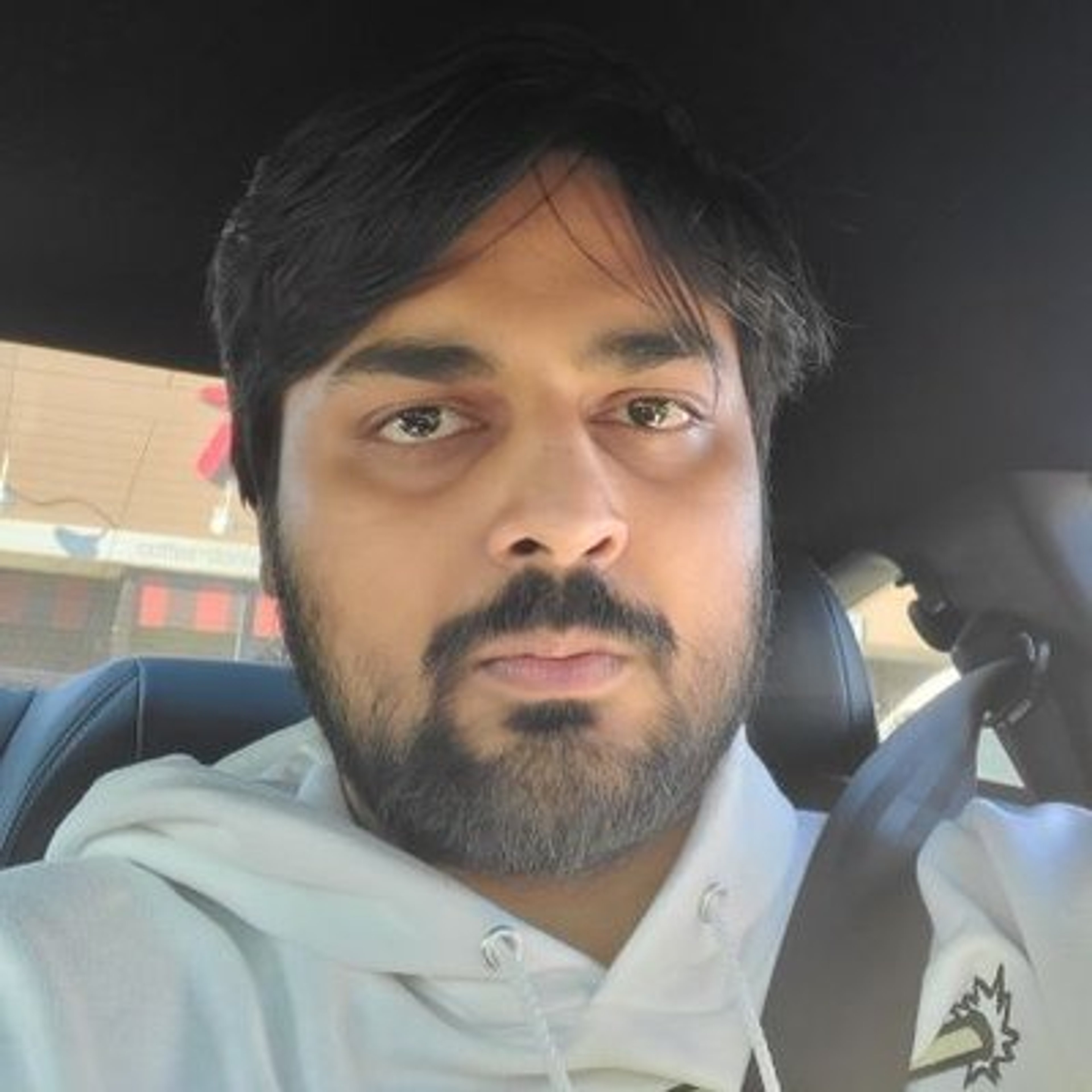 A man with a beard sitting in a car