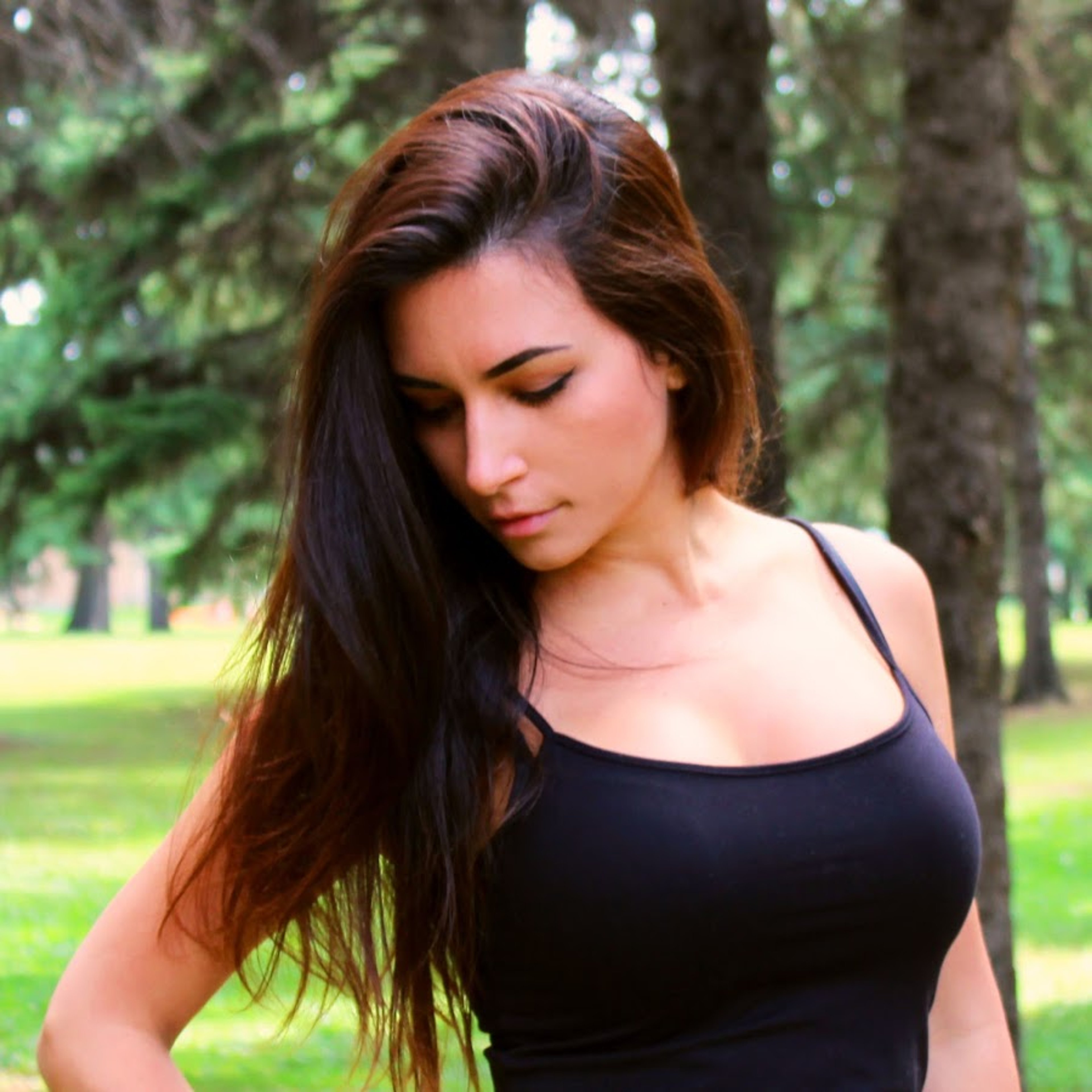 A young woman with long dark hair wearing a black tank top