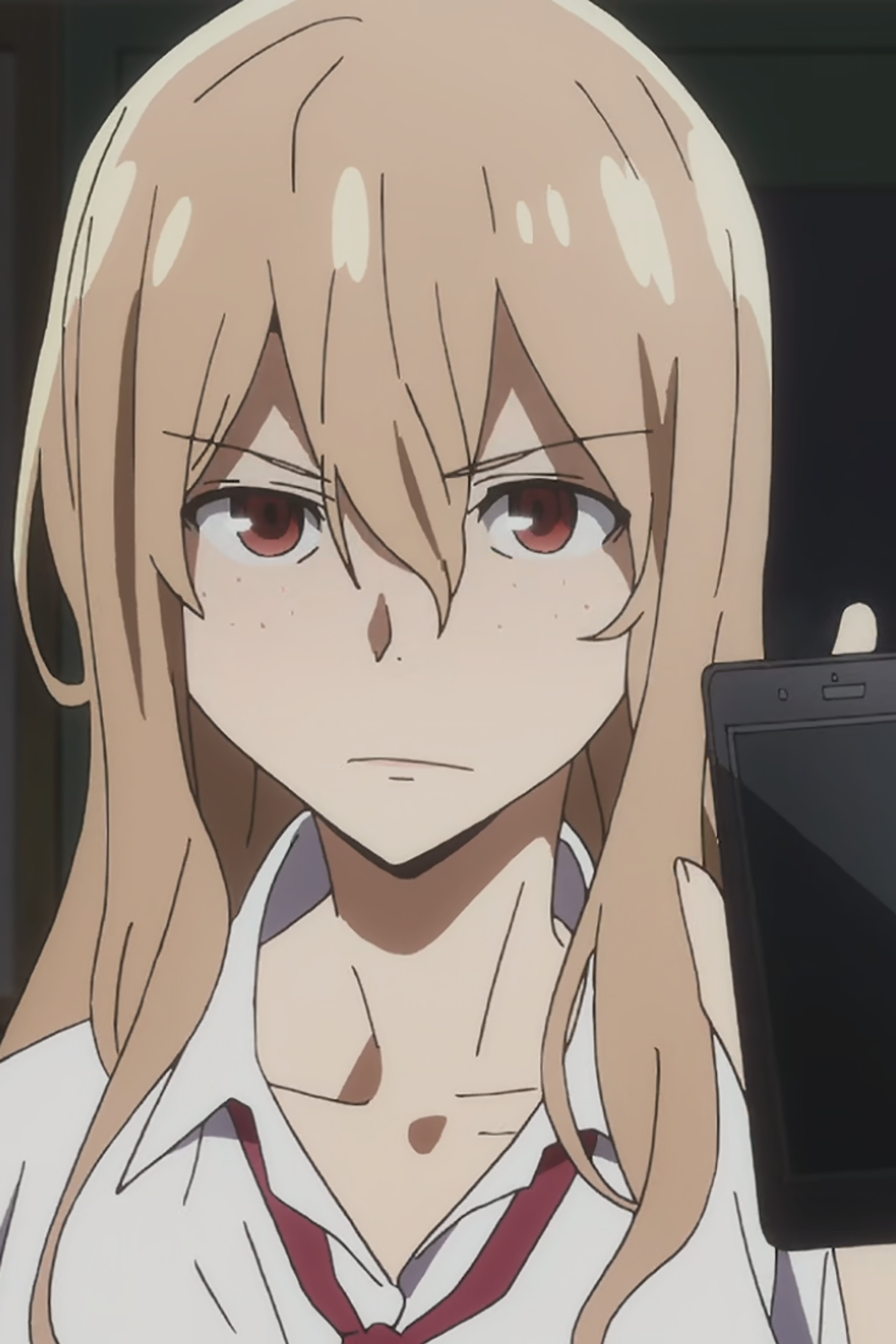 A young woman with light brown hair and a serious expression, wearing a school uniform.