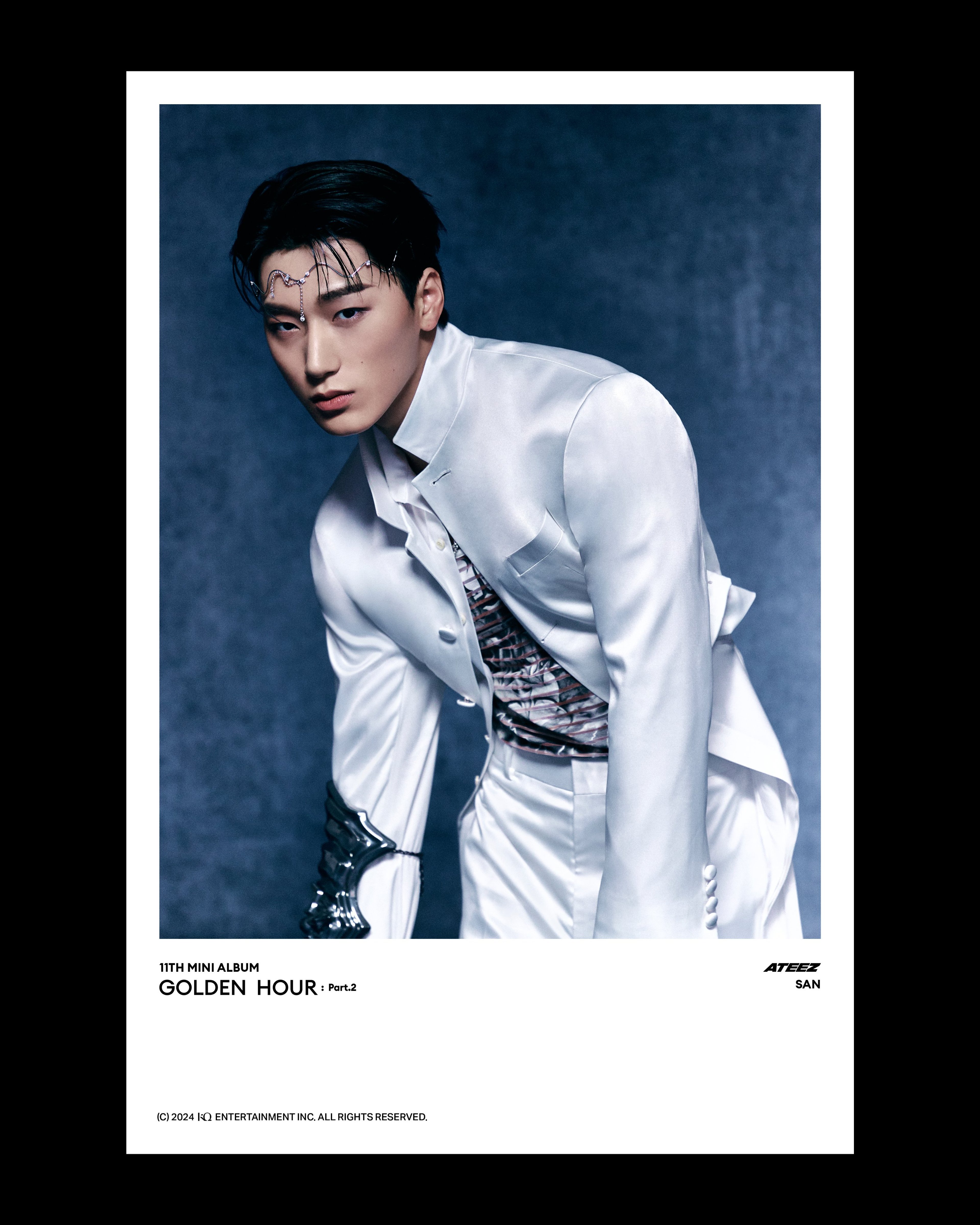 A young man with dark hair wearing a white shirt and tie, looking serious and intense.